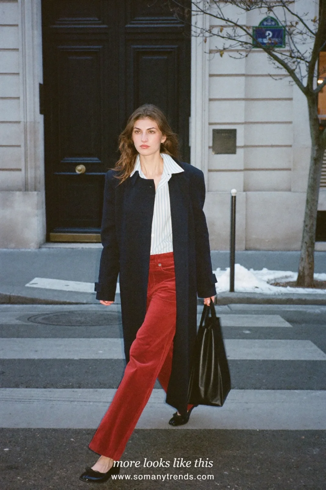 Woman in a blue striped shirt, red corduroy straight pants, navy coat and black flats on a Paris street, outfit 30
