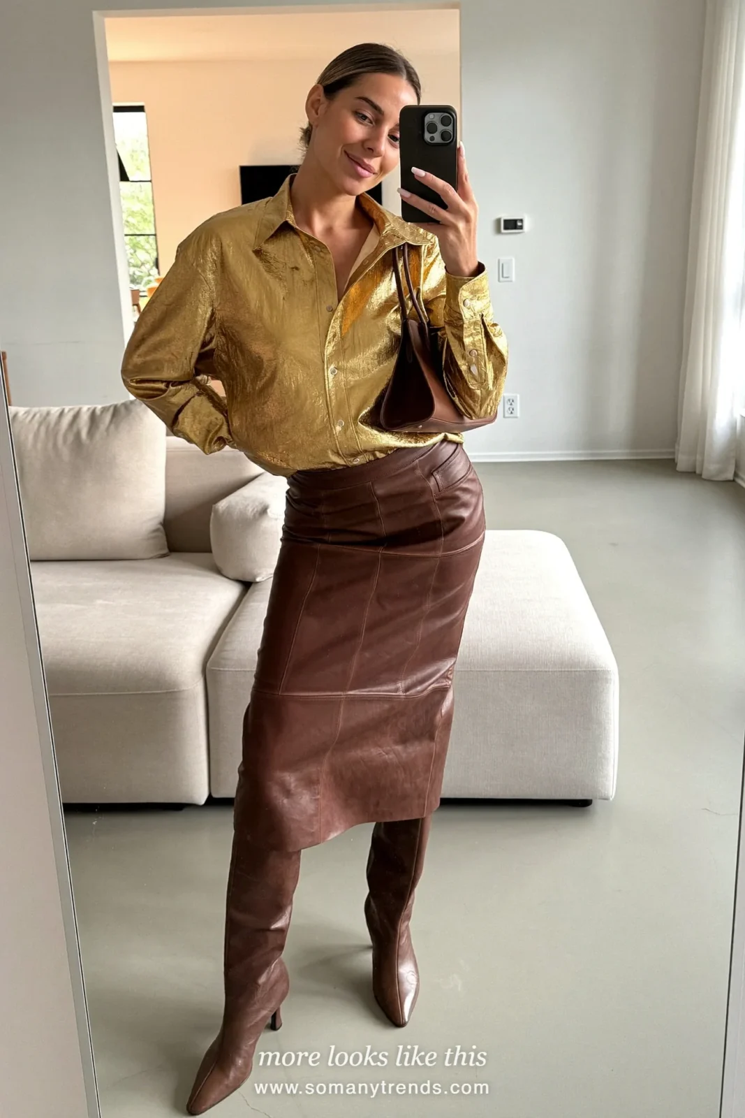 Woman in a gold metallic shirt, chocolate brown leather midi skirt and tall brown boots on a staircase, outfit 12