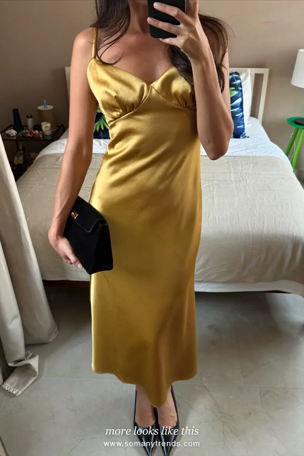 Woman in a long black wool coat and a gold satin slip dress with black pumps at a party entrance, outfit 20