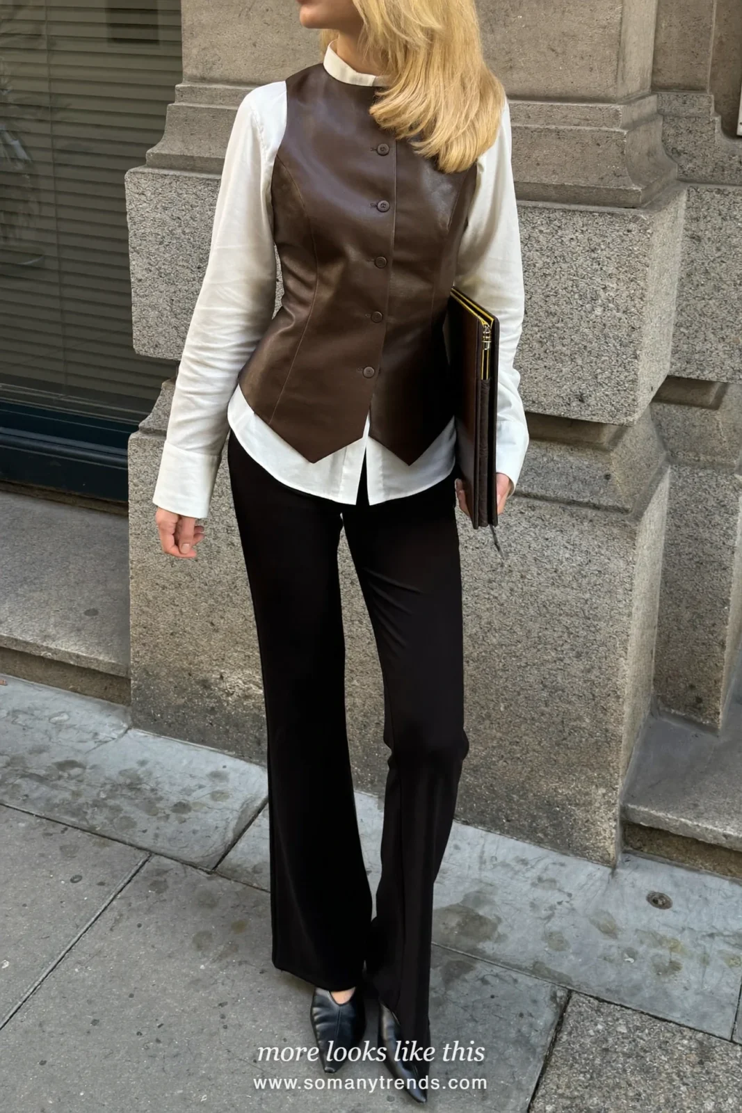 Woman in a white shirt, brown vest, black flare pants and pointed heeled loafers outside an office, outfit 26