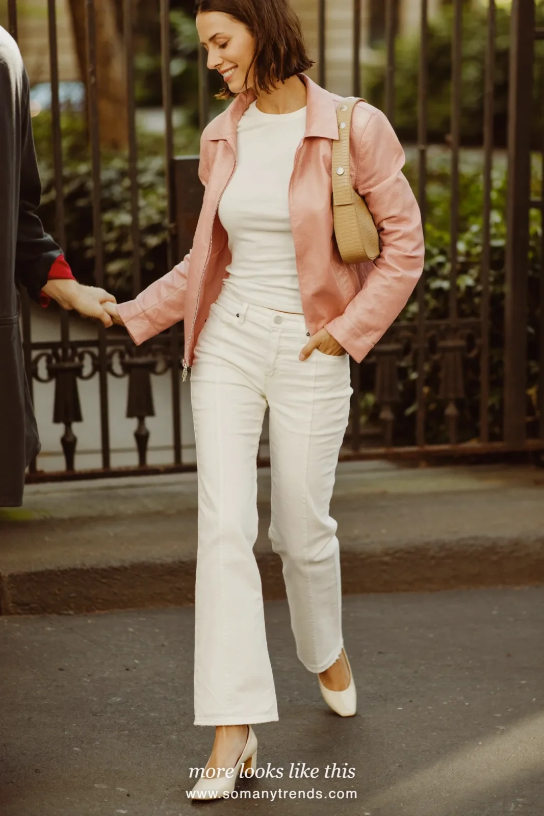 Woman in a short rose jacket, white tee, white flare jeans and cream almond-toe pumps on a city street, outfit 29