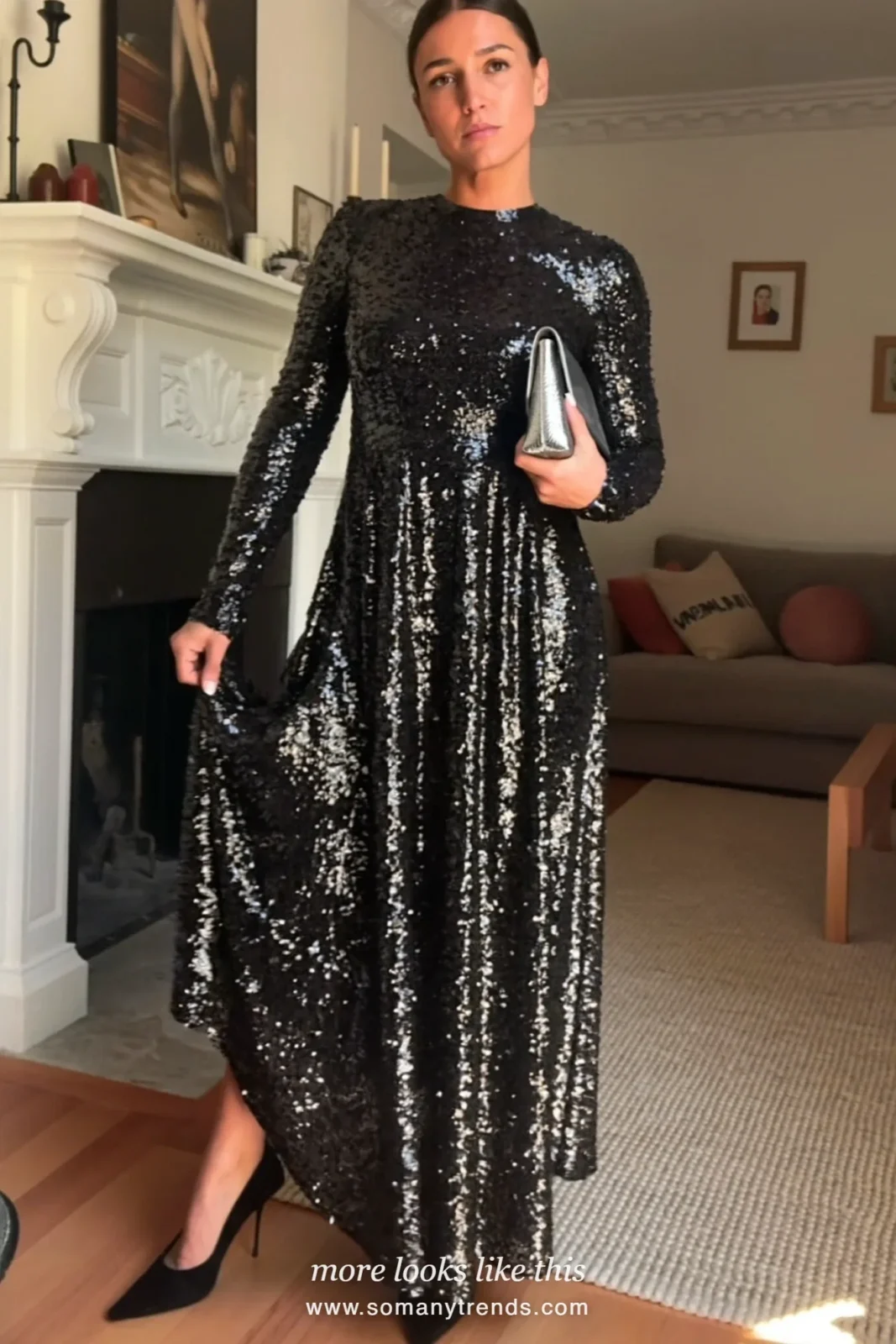 Woman in a black sequin long-sleeve maxi dress with black pointed pumps in a cozy room with a fireplace, outfit 7