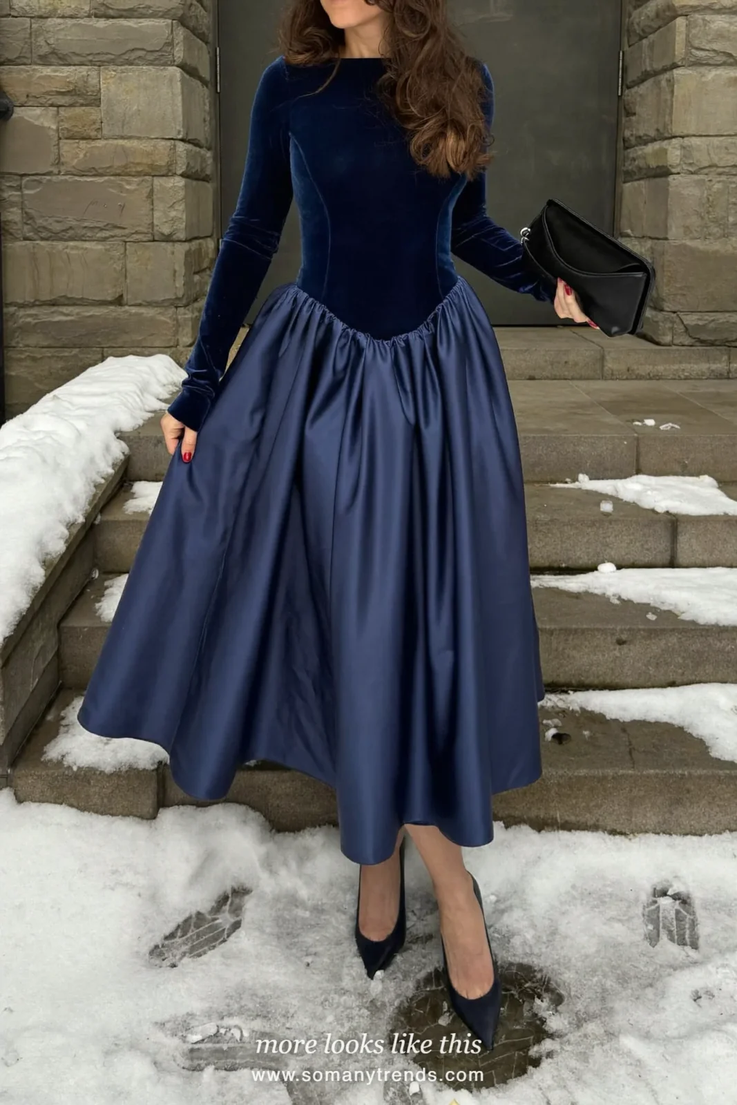 Woman in a navy velvet bodice dress with a flared satin skirt and navy pumps at a stone church, outfit 19
