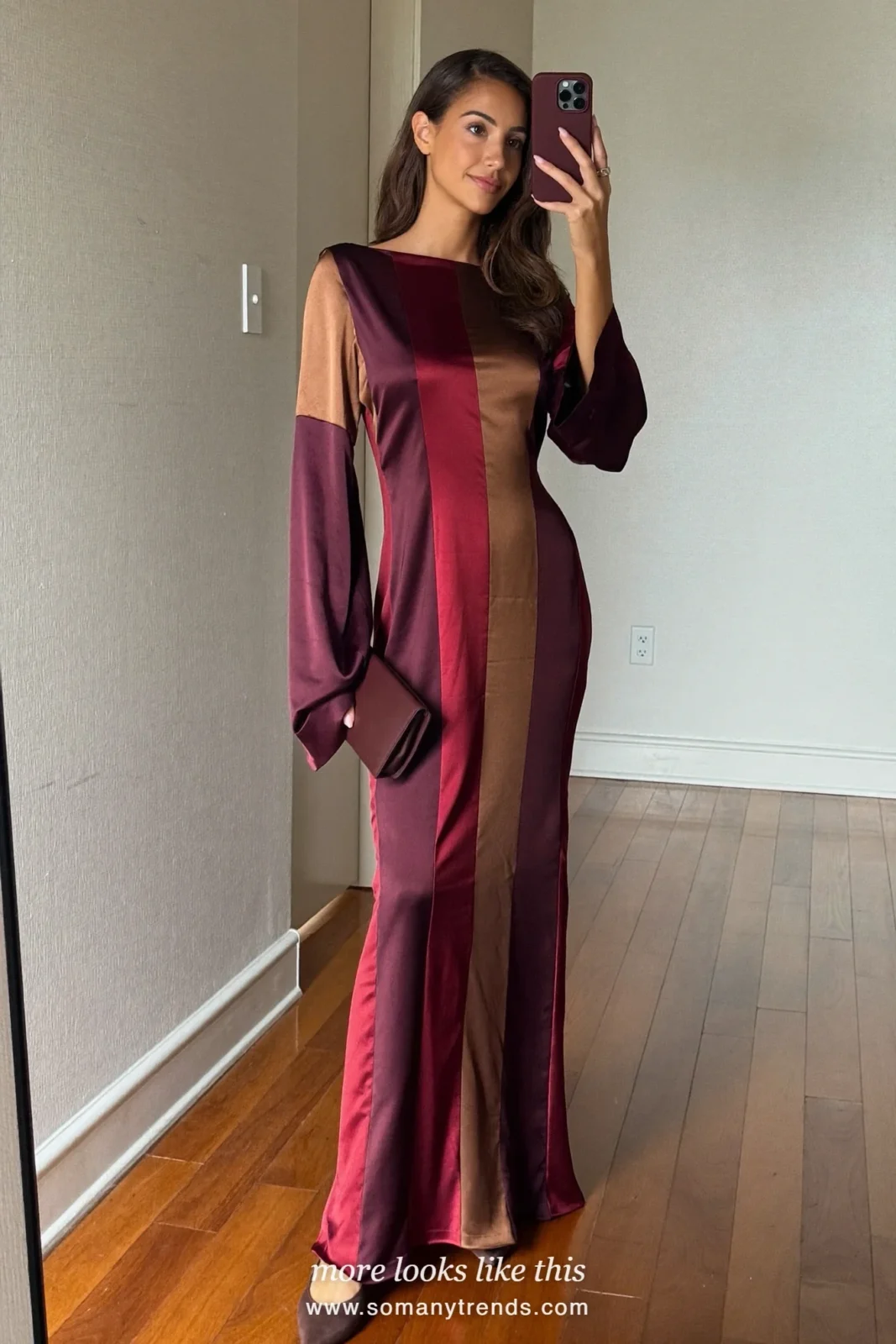 Woman in a burgundy and espresso color-block satin gown with brown pumps in a room with a fireplace, outfit 28