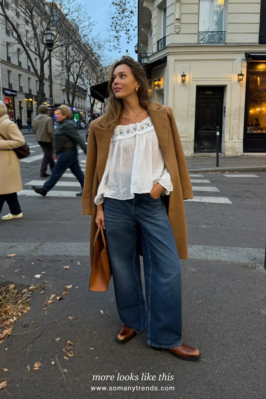 Woman in a white embroidered peasant blouse, dark jeans, brown boots and long camel coat in Paris, outfit 15