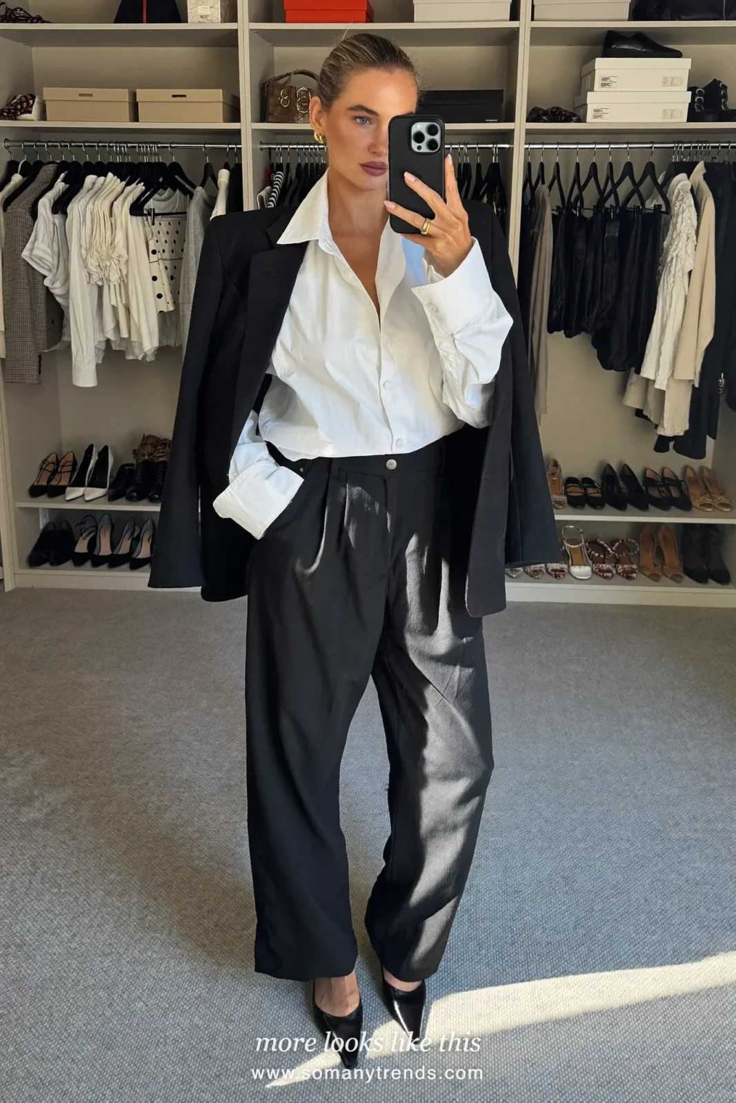 Woman in a black blazer and trousers with a white shirt and pointed black pumps on a Paris street, outfit 20