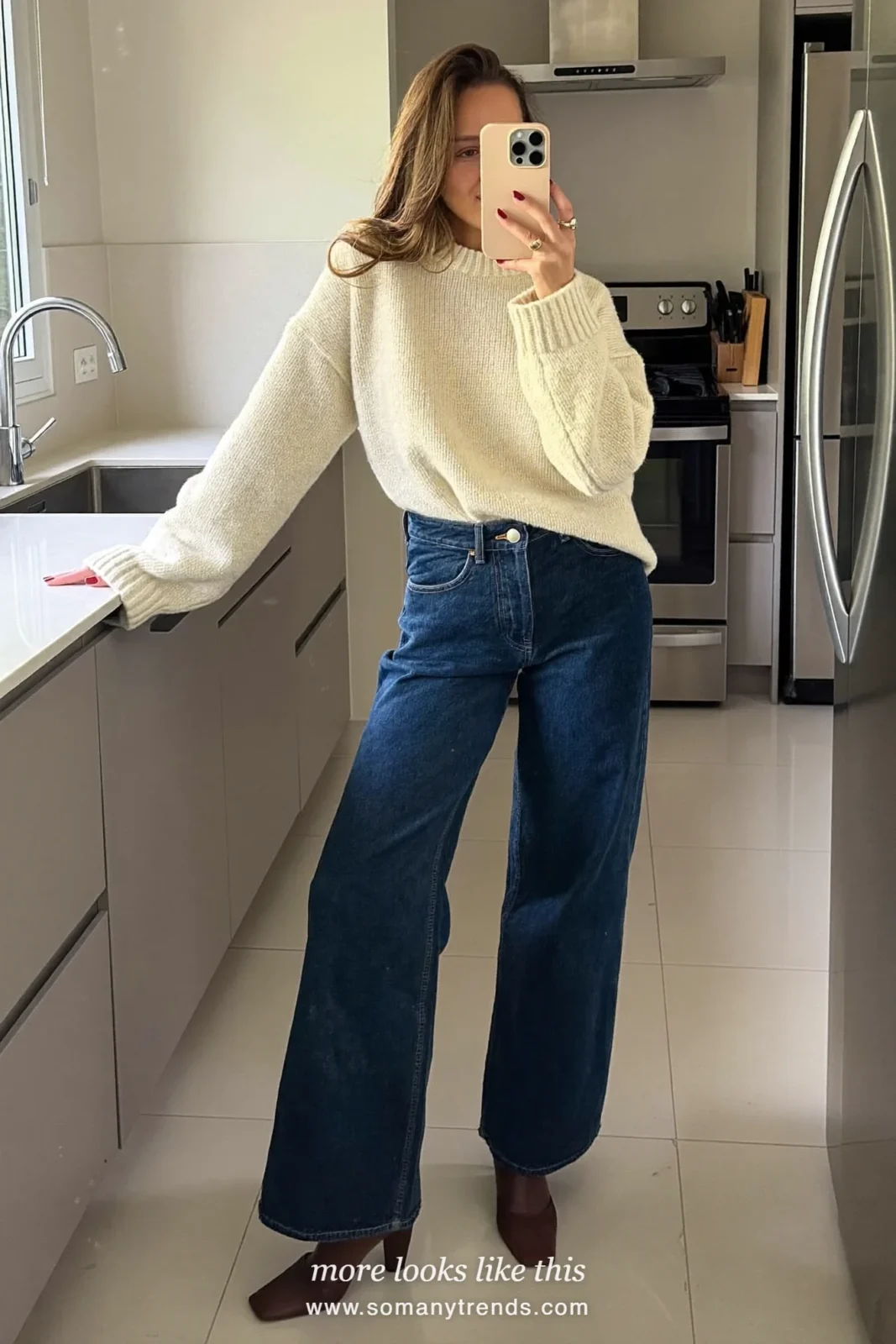 Woman in a cream fisherman sweater, dark jeans, brown boots and a woven basket at a Paris market, outfit 28