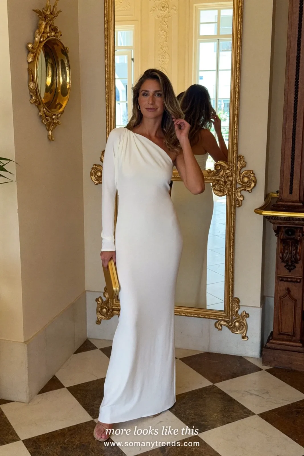 Woman in a white crepe one-shoulder gown in a gilded hotel lobby, outfit 19