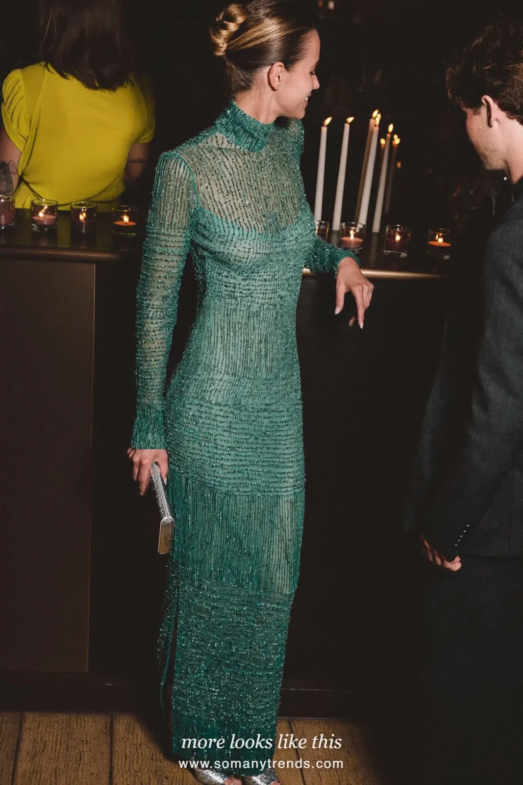 Woman in a teal beaded long-sleeve gown at a candlelit bar, outfit 25