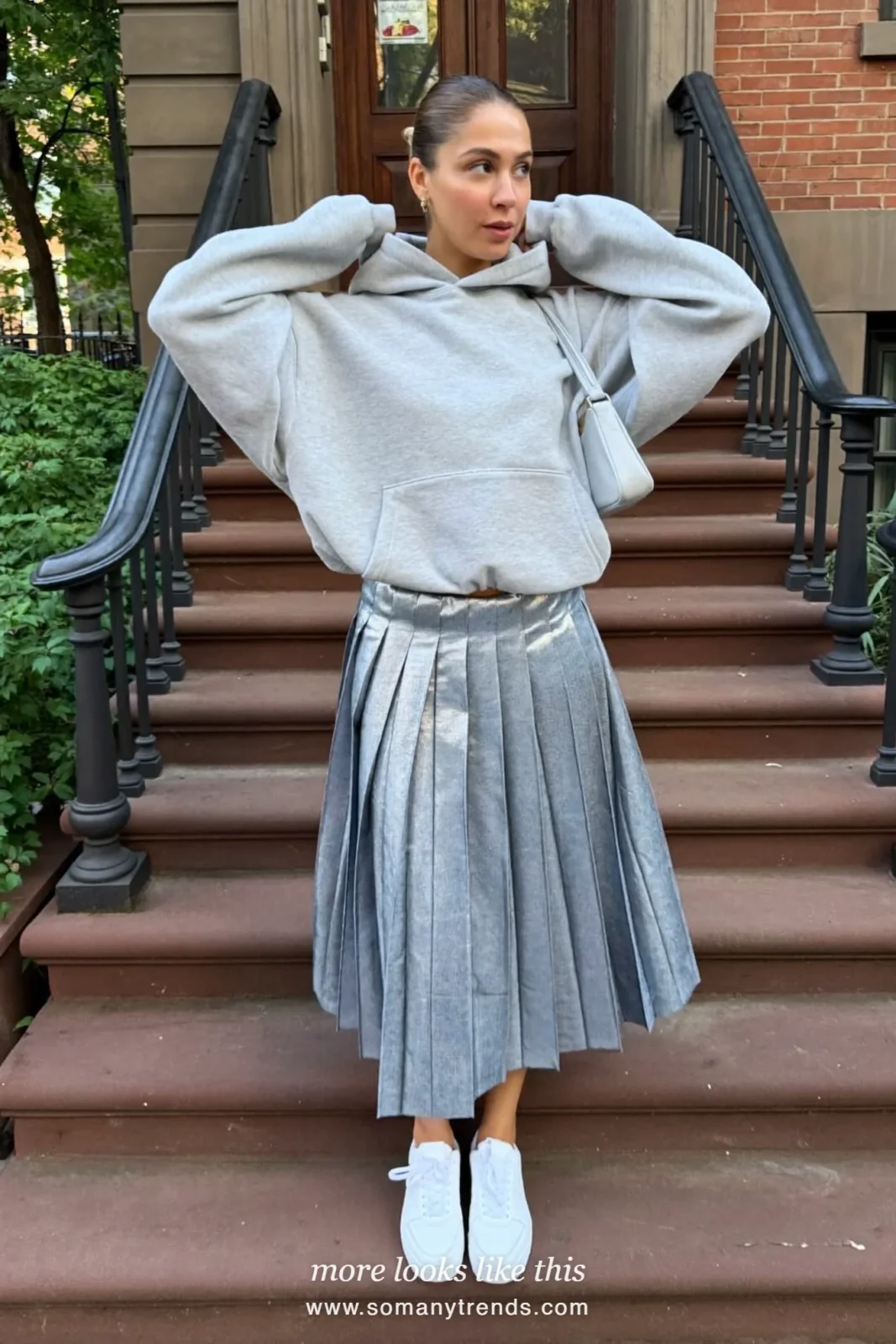 Woman in a pleated blue metallic midi skirt, gray hoodie and white sneakers, house party outfit 22
