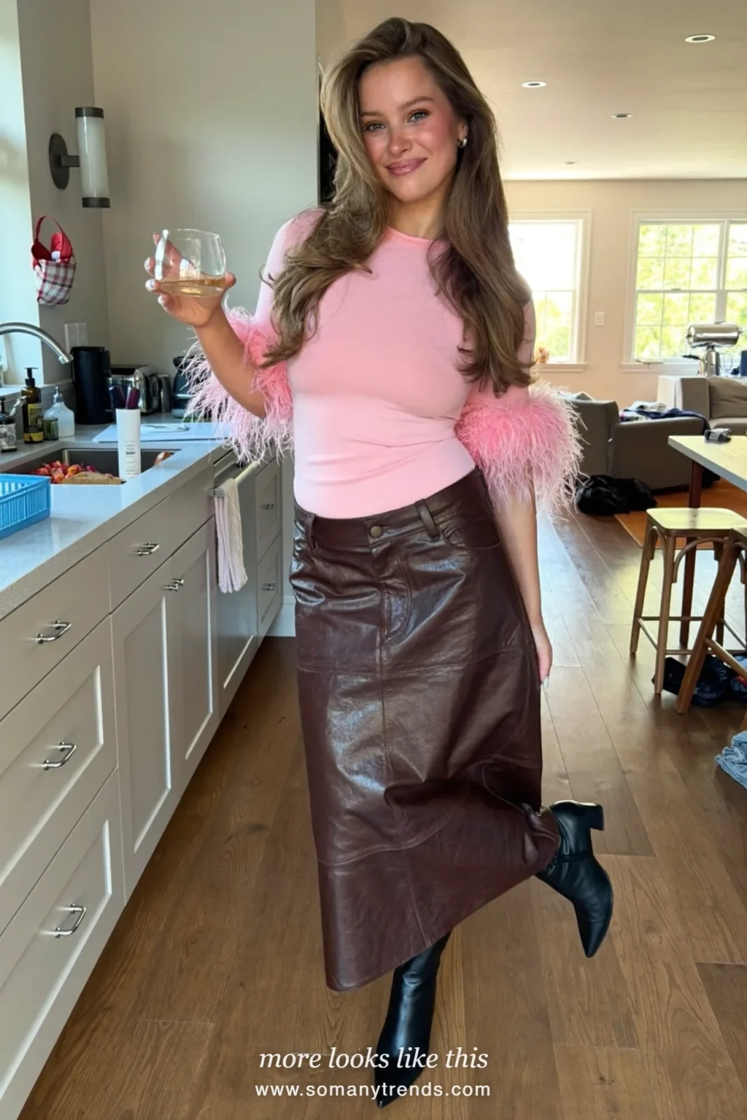 Woman in a pink feather top, brown leather midi skirt and black pointed boots, house party outfit 25