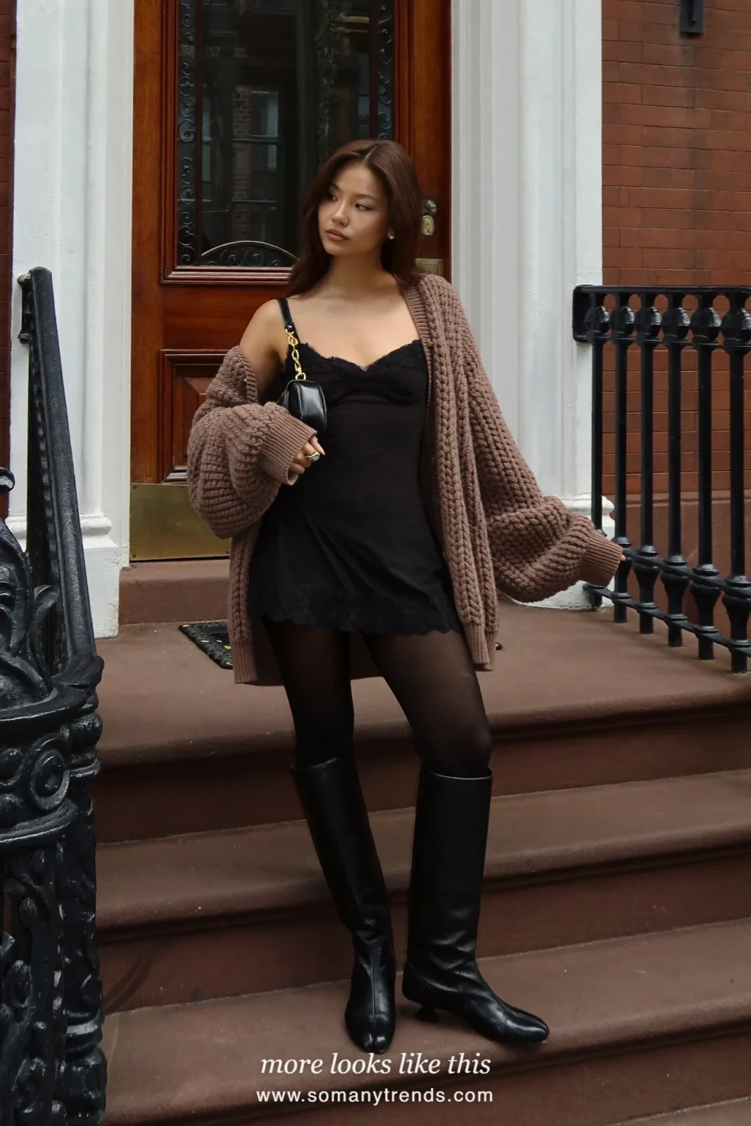 Woman in a black lace-trim mini dress, mocha chunky cardigan and black knee-high boots, house party outfit 27