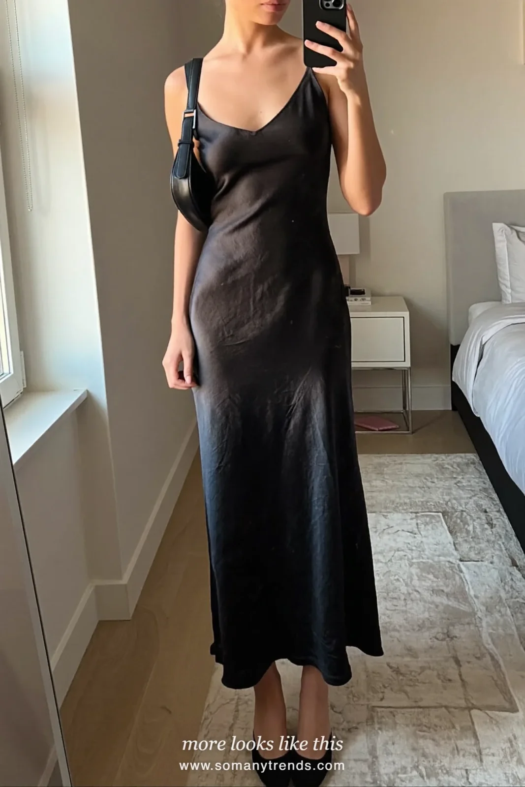 Woman in black satin slip maxi dress, kitten heels and black shoulder bag taking a mirror selfie, outfit 4