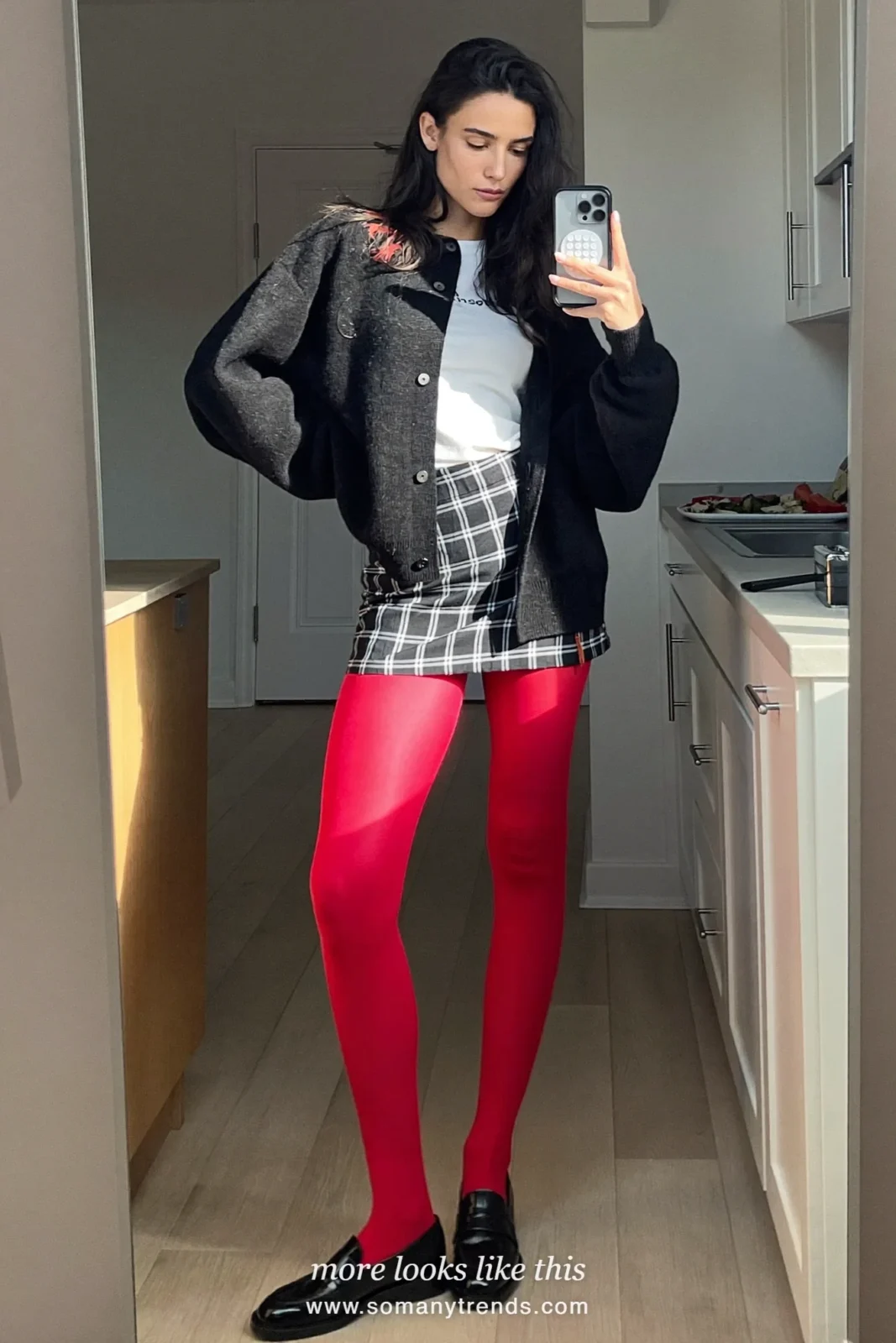 Woman in a black cardigan, white tee, plaid mini skirt, red opaque tights and black loafers, outfit 24