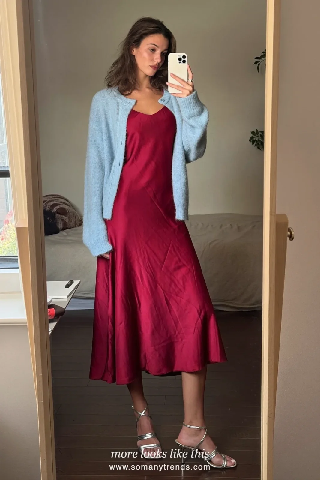 Woman in a burgundy satin slip dress, a baby blue mohair cardigan and silver heeled sandals, outfit 6