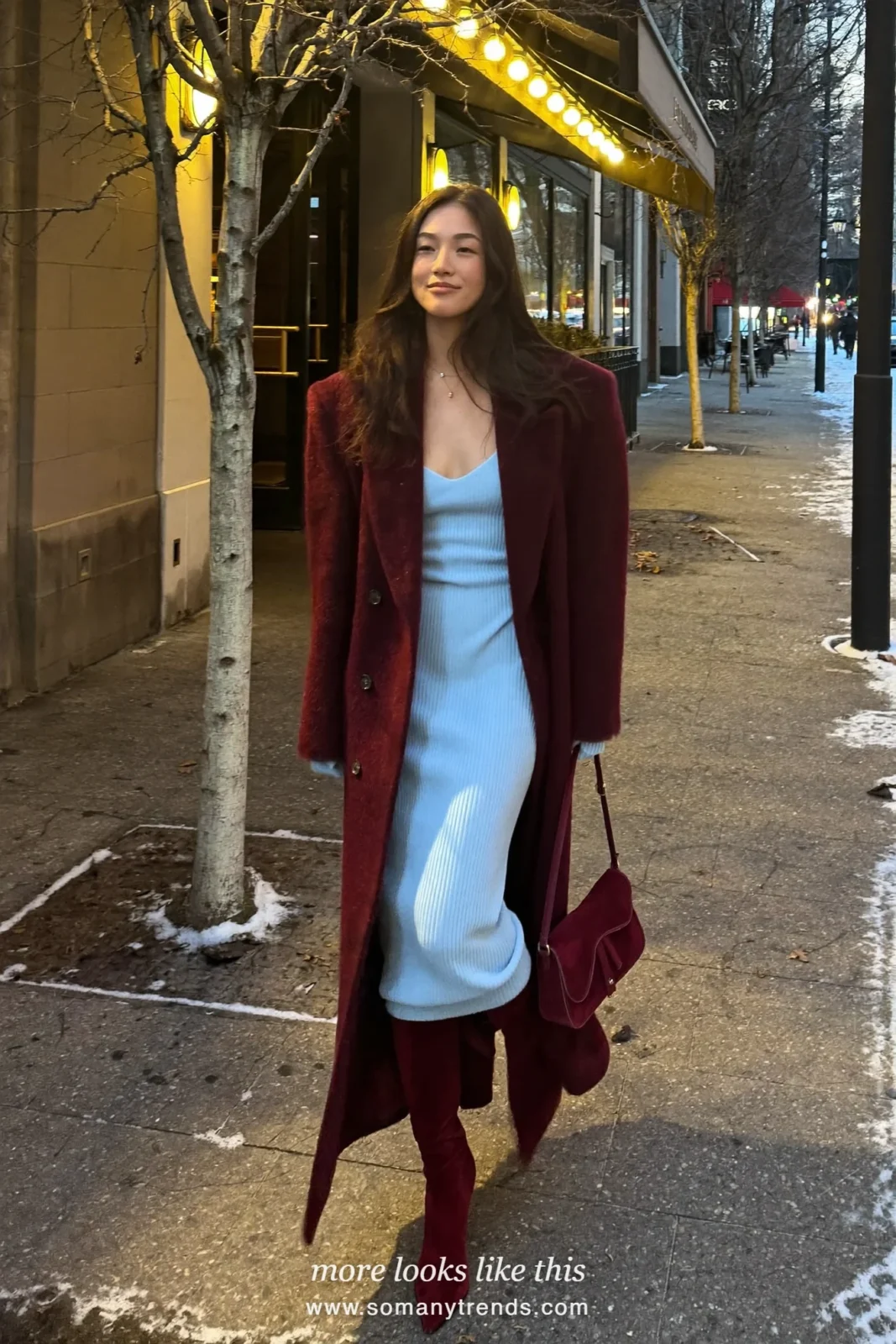 Woman in a long burgundy coat over a baby blue knit column dress with burgundy suede knee boots, outfit 8