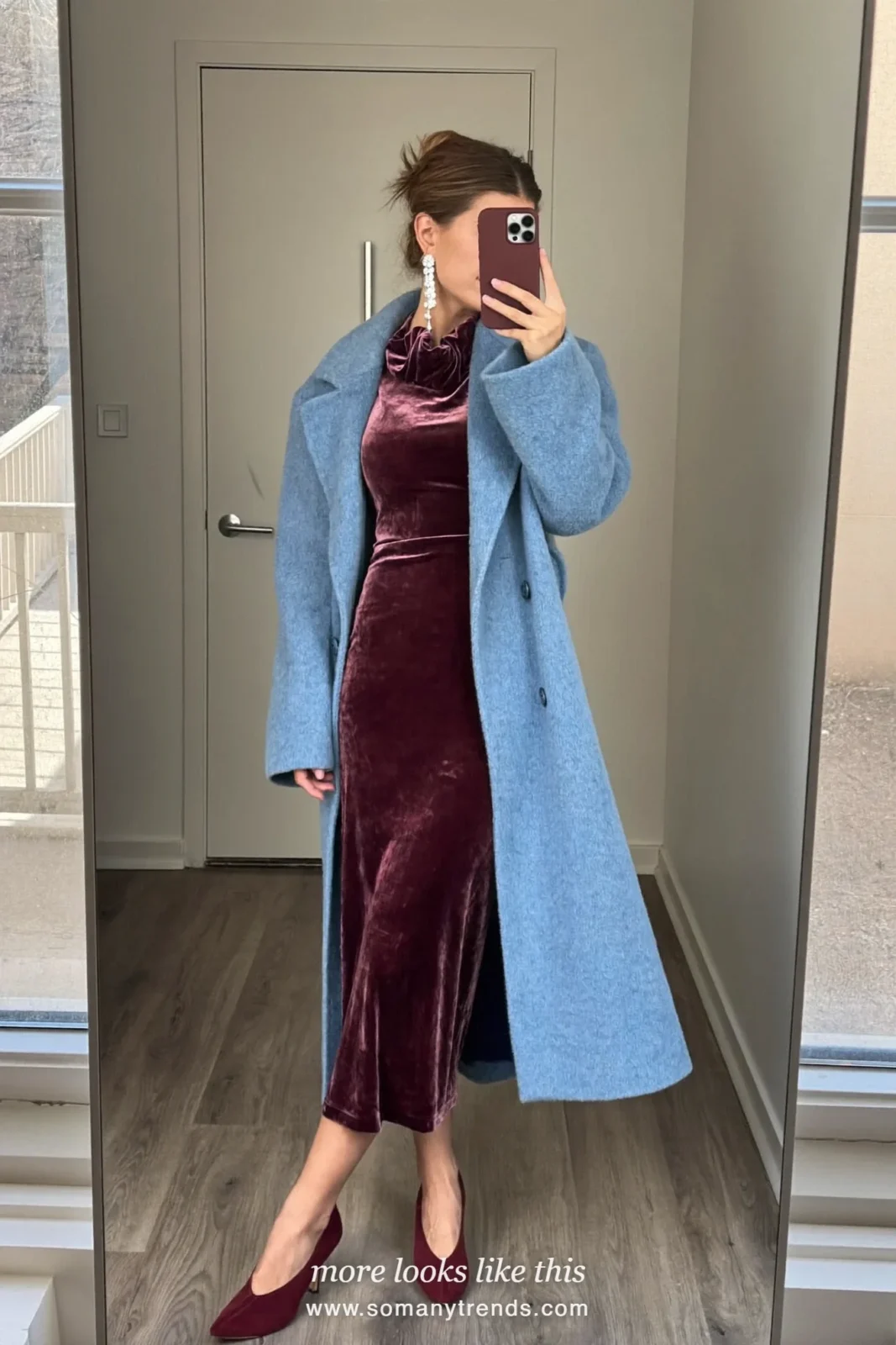 Woman in an icy baby blue long coat over a burgundy velvet midi dress with burgundy suede pumps, outfit 15