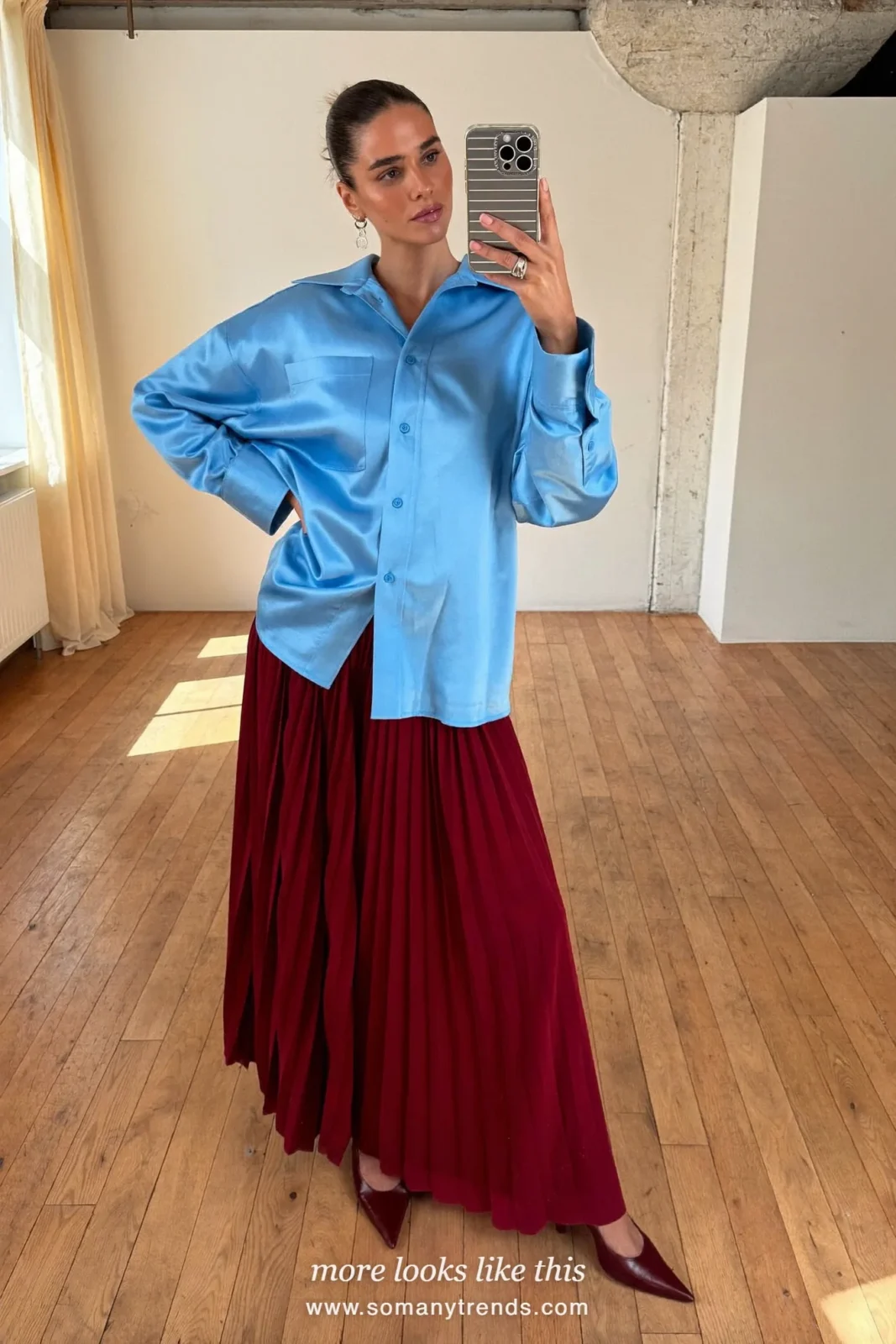 Woman in an icy blue satin shirt, a burgundy crepe maxi skirt and burgundy pointed pumps, outfit 24