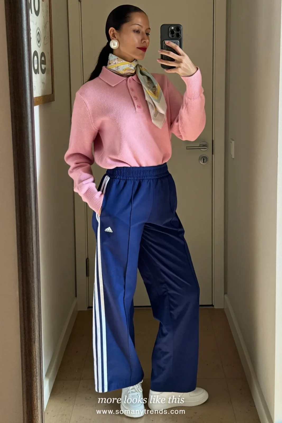 Woman in clearly navy blue track pants with white side stripes, baby pink polo and white sneakers, outfit 3
