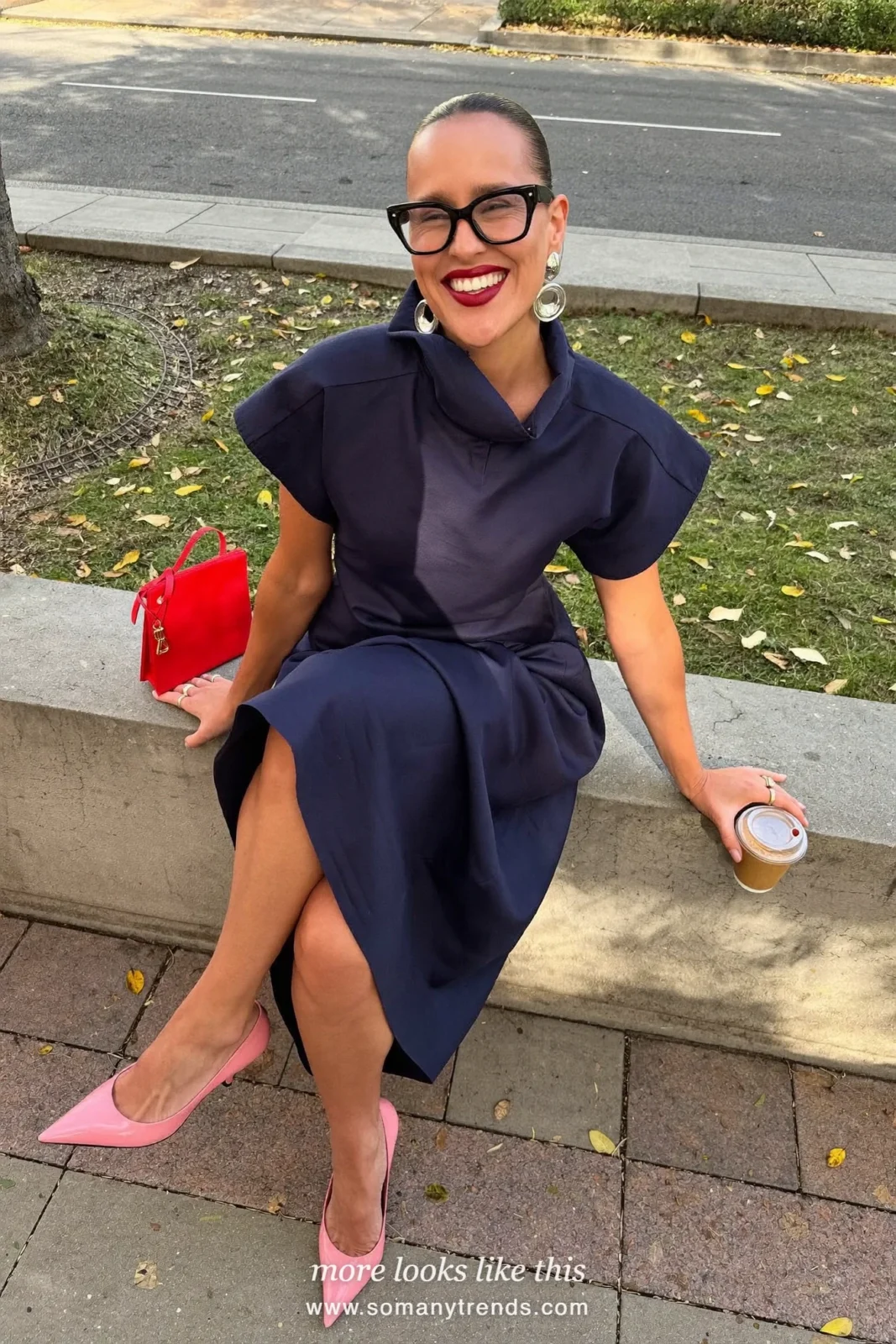 Woman in a navy blue midi dress with baby pink heels and a pink clutch, outfit 22