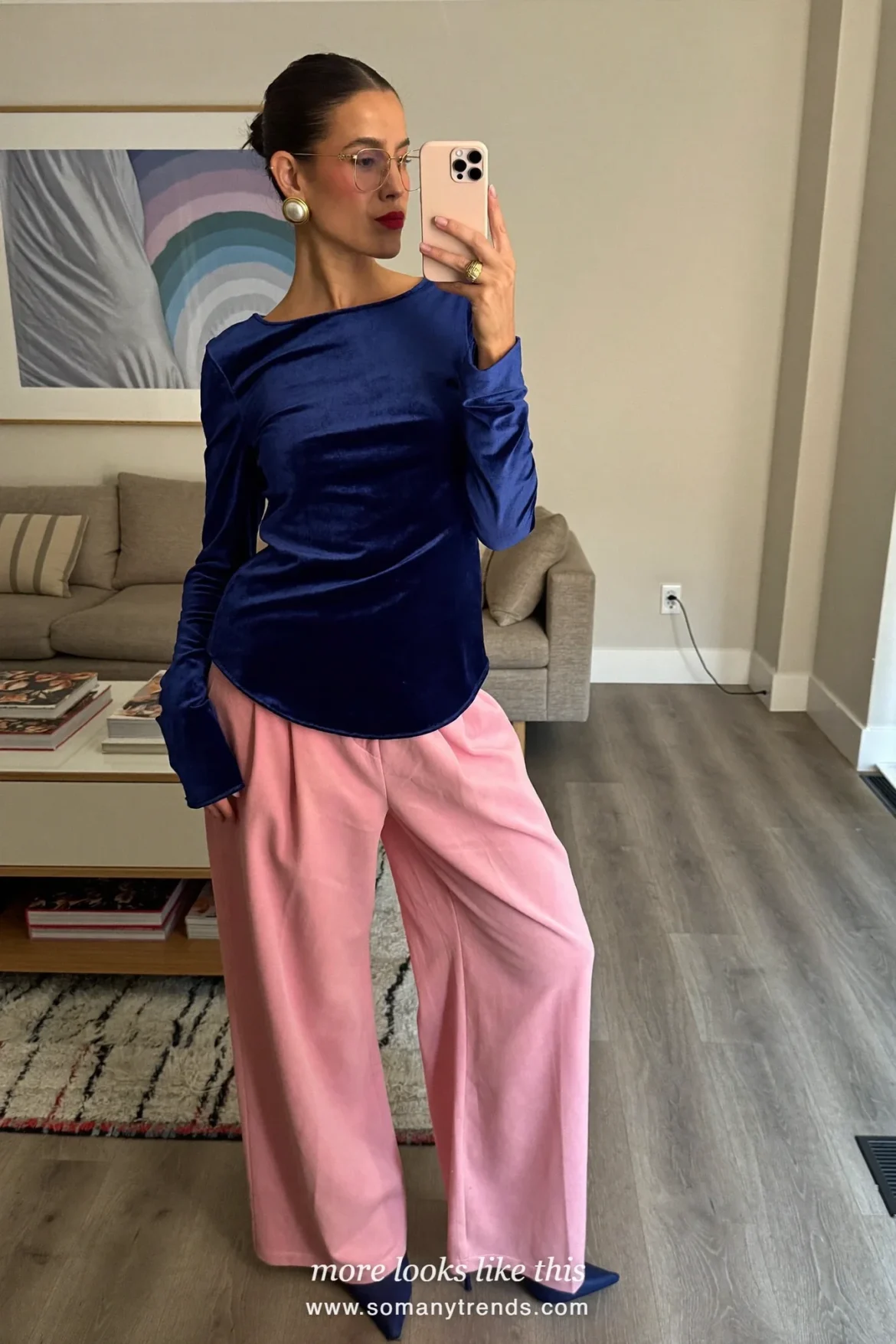 Woman in a navy blue velvet top, wide pink trousers, navy heels and a small gold bag, outfit 24