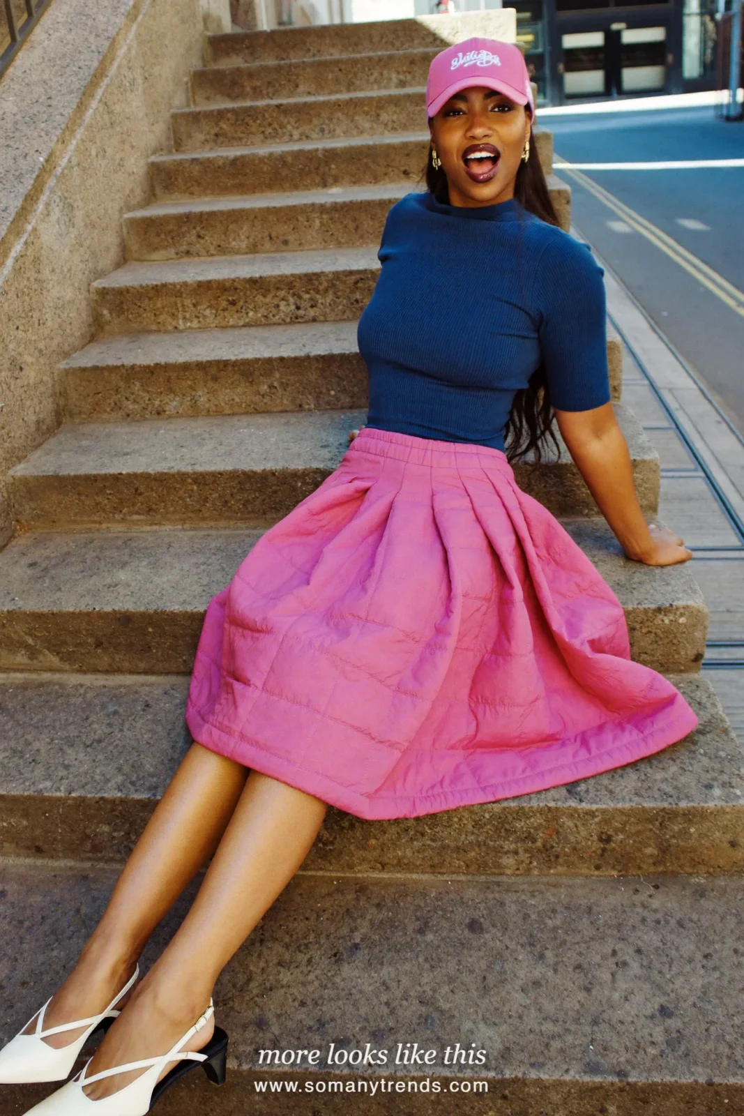 Woman in a hot pink quilted midi skirt, navy blue fine knit top and white slingbacks, outfit 5