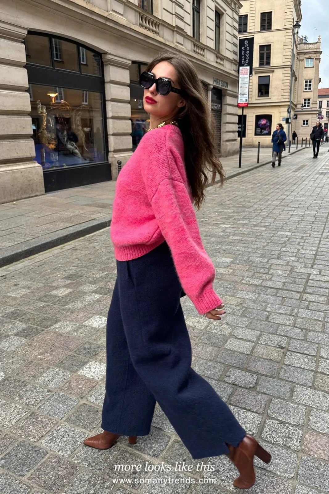 Woman in a hot pink crewneck sweater, navy blue wide wool pants and a tan tote bag, outfit 10