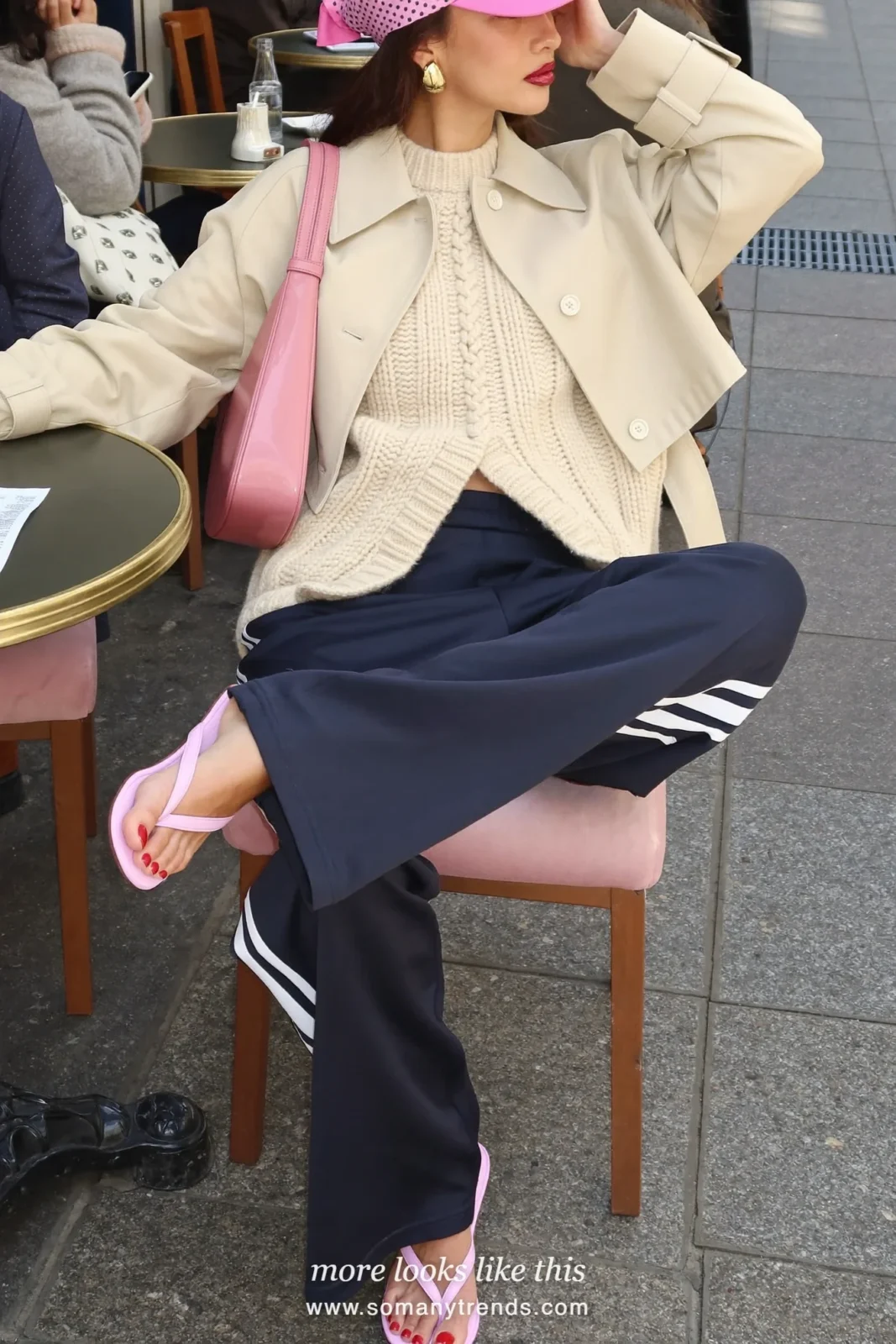 Woman in navy blue track pants, cream chunky knit, short beige trench, pink polka-dot headscarf and pink sandals, outfit 13