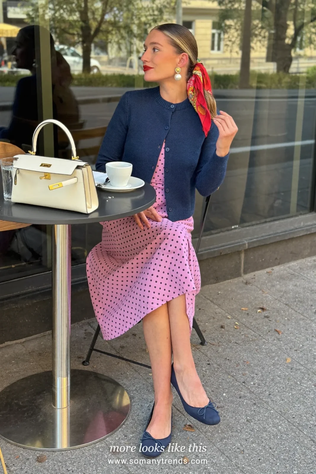 Woman in a pink polka-dot midi dress, navy blue cardigan and navy ballet flats, outfit 19