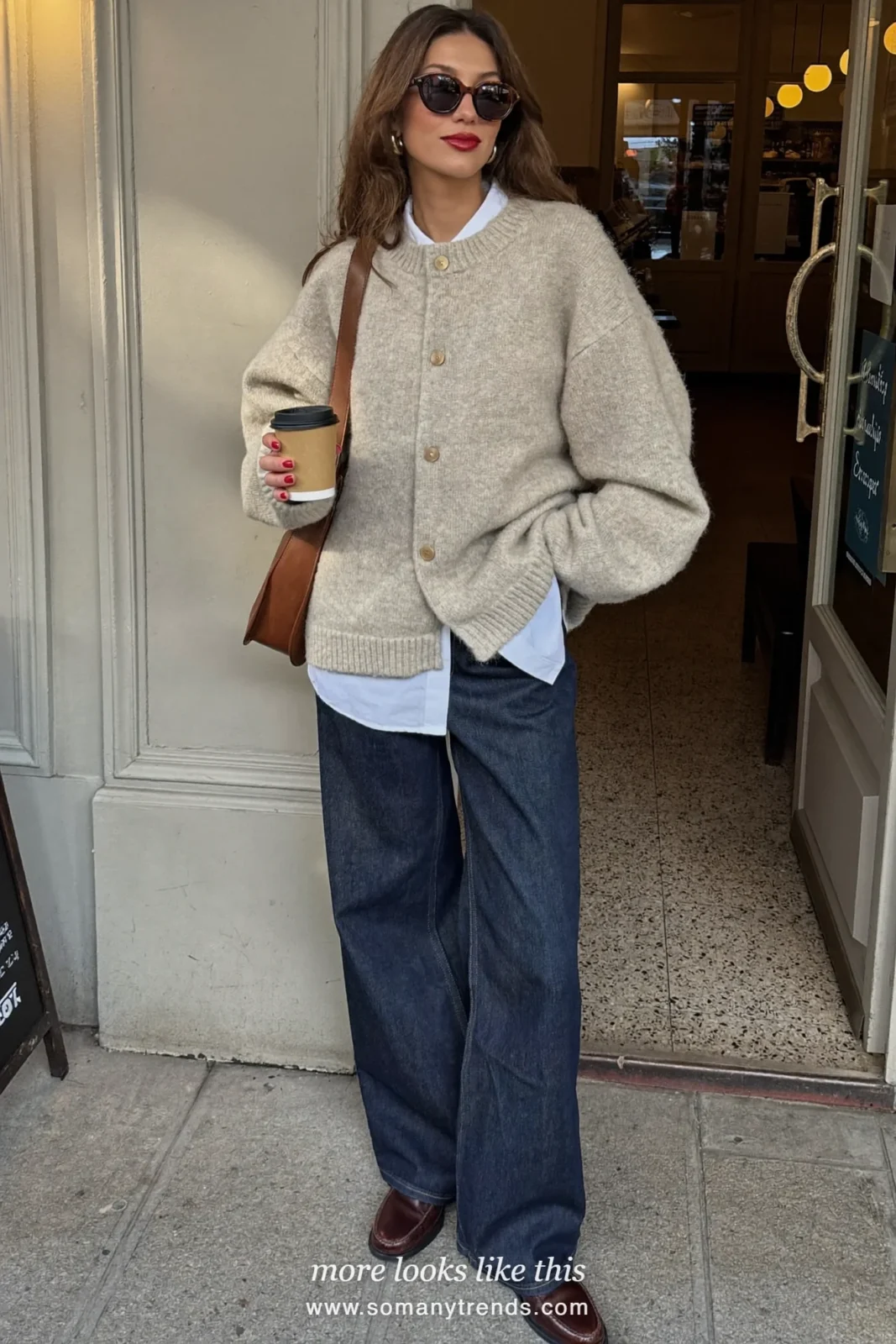 Oversized oatmeal cardigan buttoned up over a white shirt with dark straight jeans and brown loafers, outfit 1