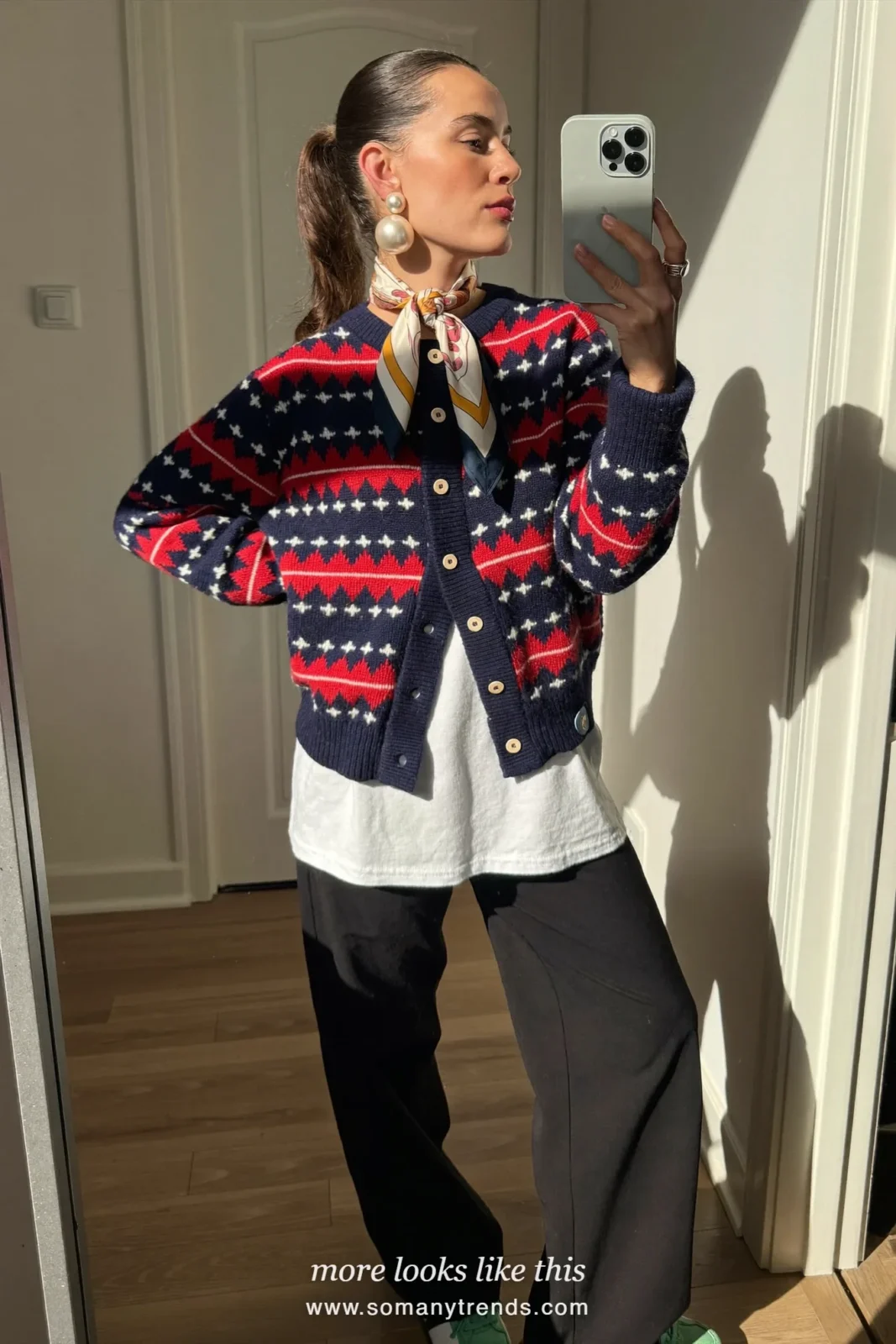 Navy cardigan with red and white diamond pattern over a white tee with black wide-leg pants and mint sneakers, mirror selfie in a hallway, outfit 3