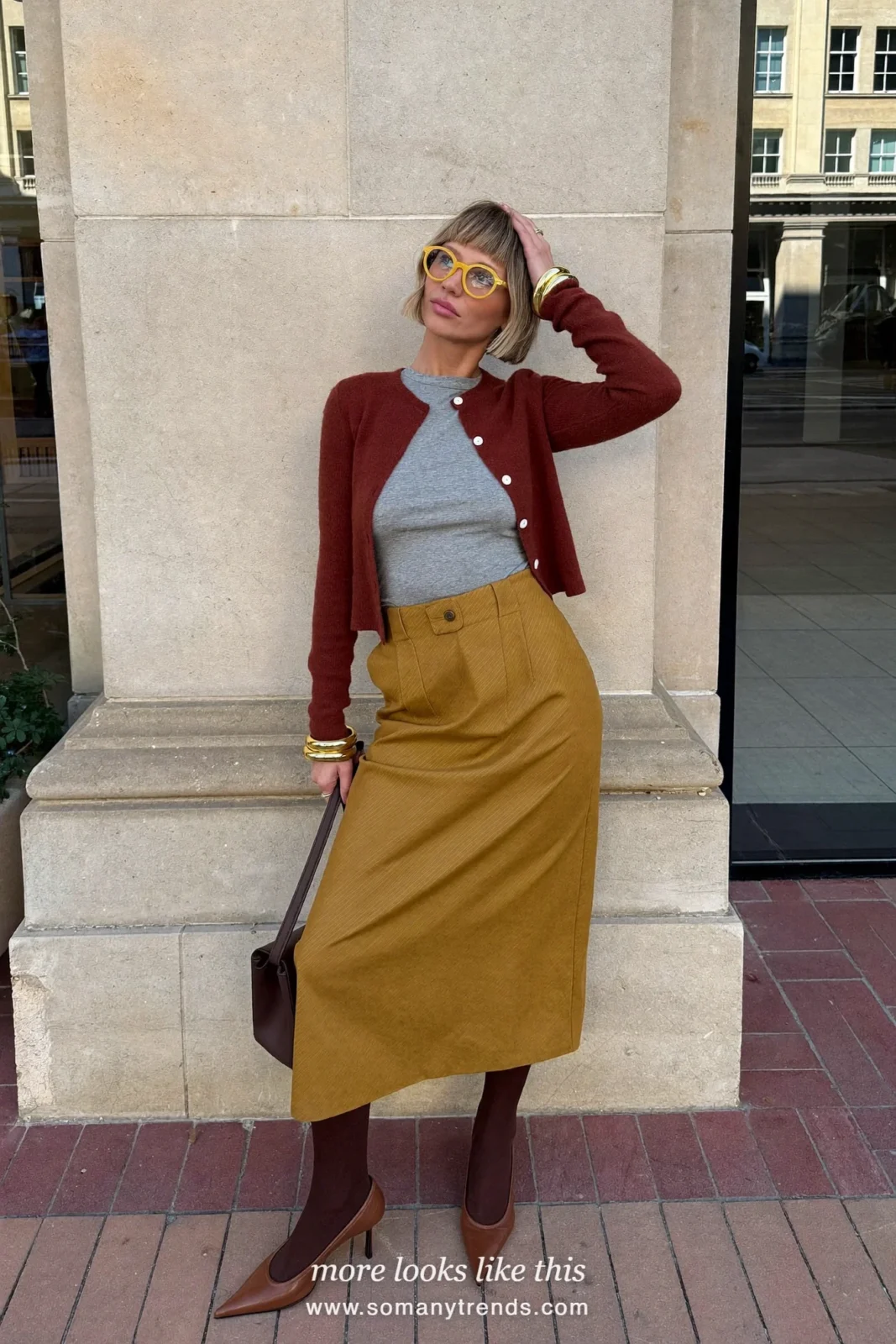 Cognac brown cardigan over a gray top with a brown leather midi skirt and tan pointed pumps, outfit 4