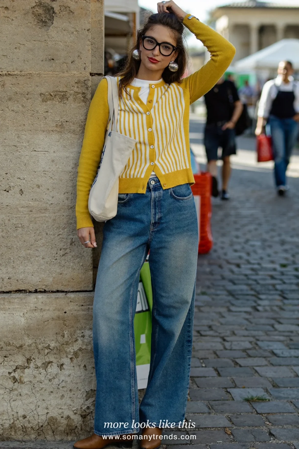 Mustard striped cardigan over a white tee with wide-leg blue jeans and tan boots, outfit 14