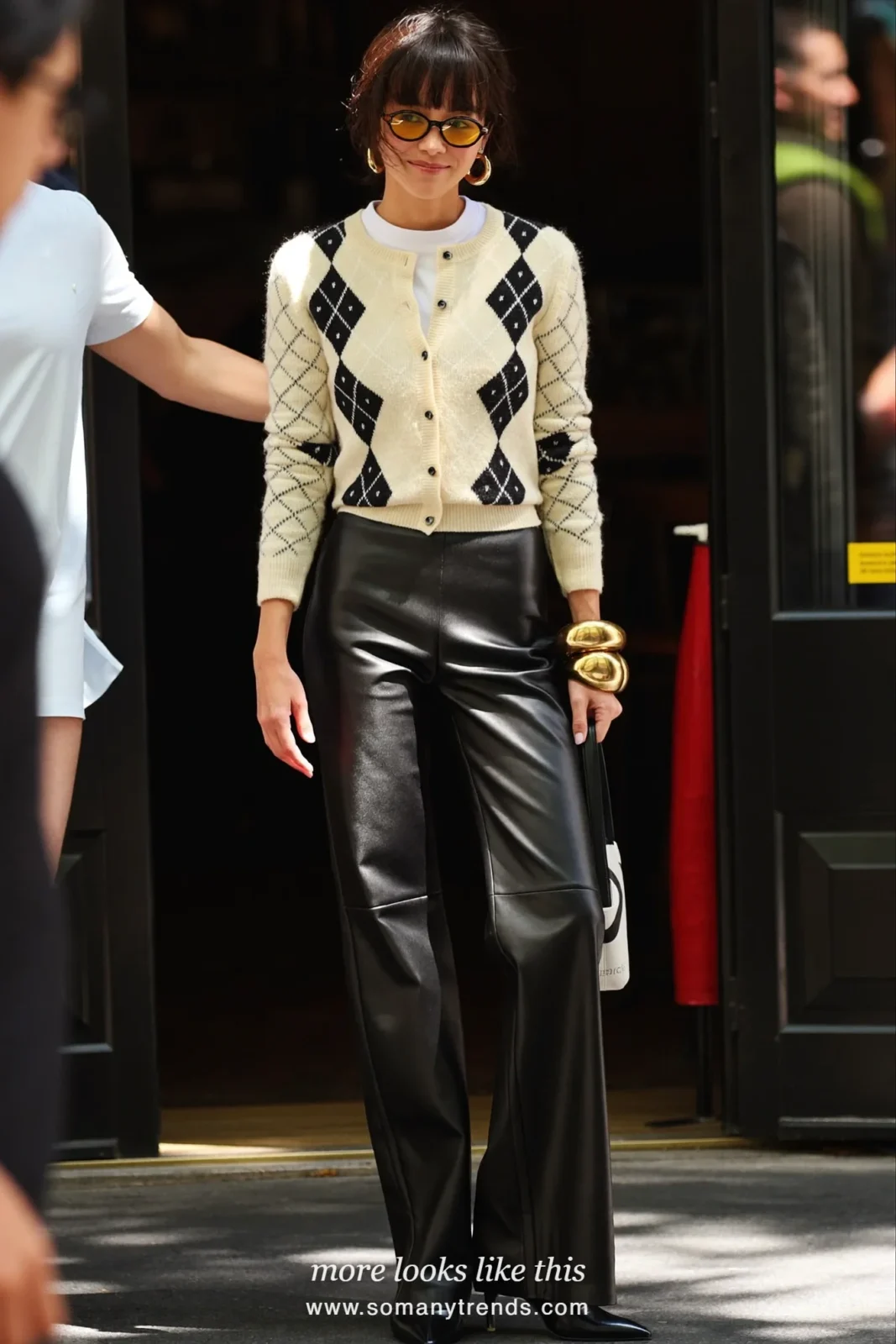 Cream argyle cardigan over a white tee with black leather pants and pointed black boots, outfit 20
