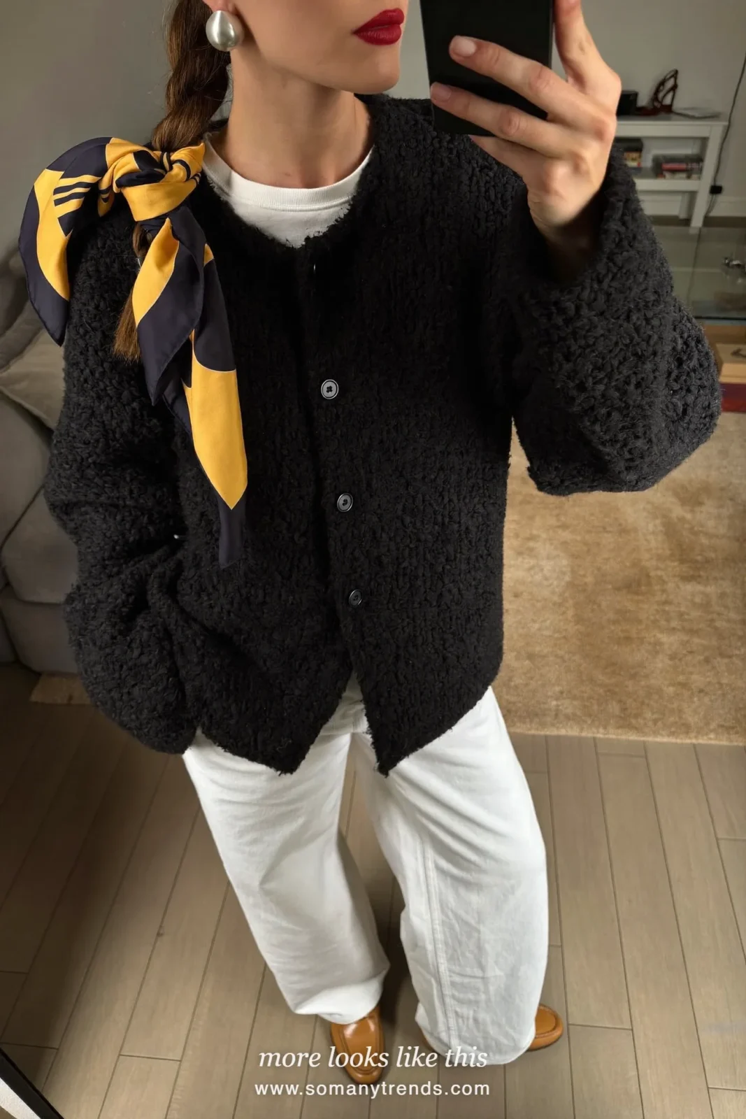 Oversized black cardigan over a white tee with white wide-leg trousers and tan loafers, mirror selfie in a living room, outfit 27