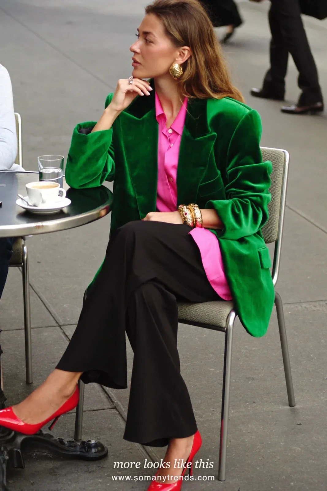 Woman in an emerald green velvet blazer, hot pink satin shirt, black wide-leg pants and red patent pumps, outfit 1