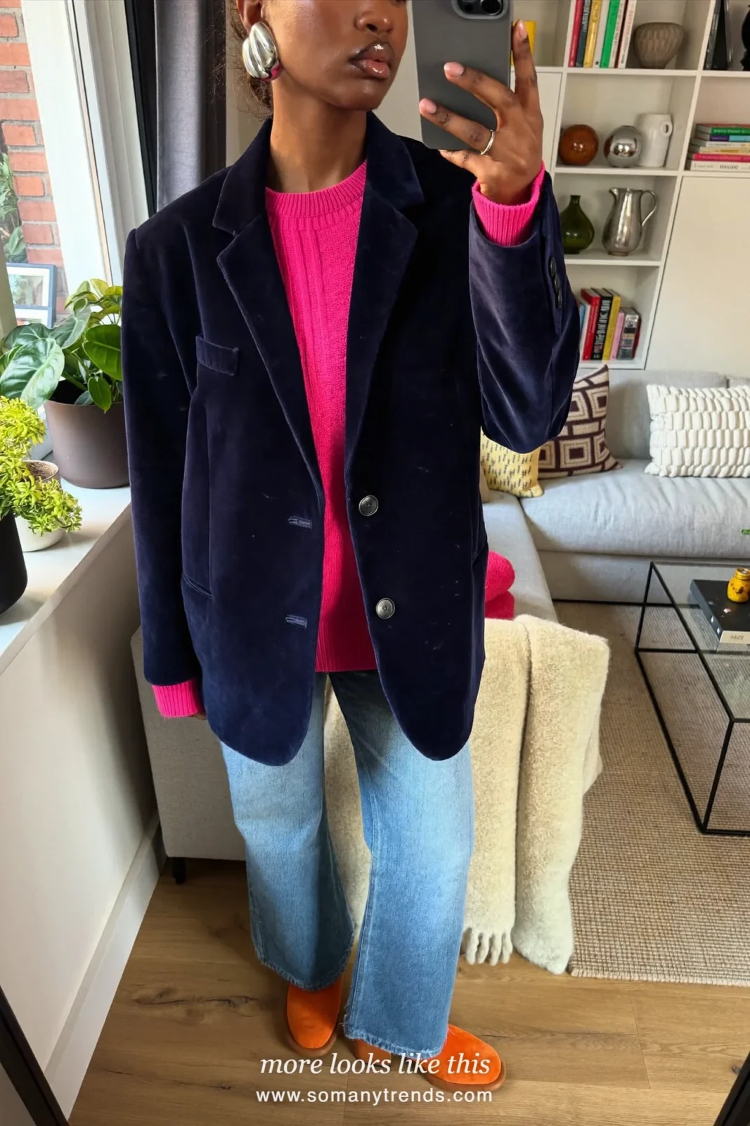 Woman in a navy velvet blazer, hot pink knit, light flared jeans and orange suede boots, outfit 12