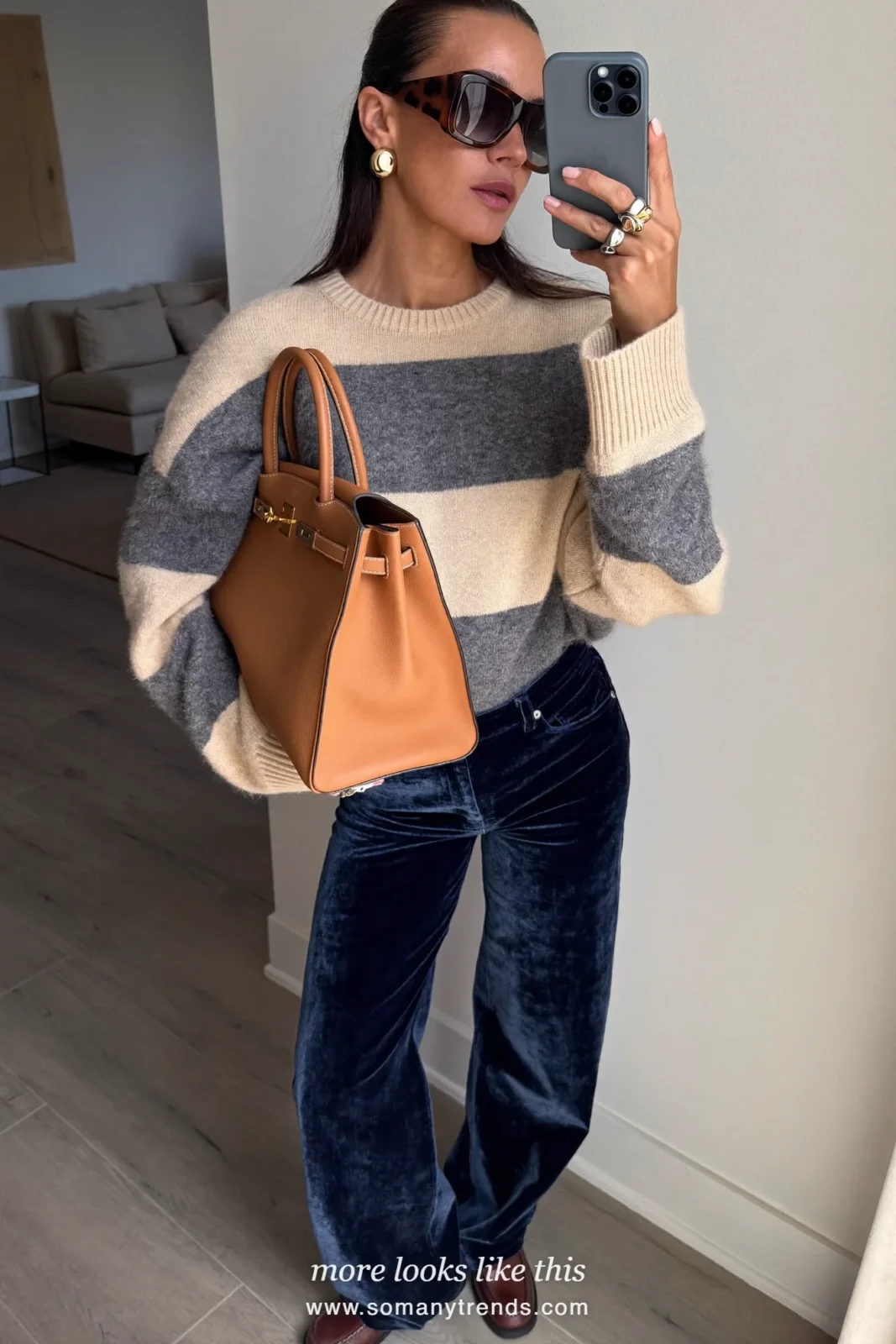 Woman in navy velvet wide pants, cream and gray striped knit, brown loafers and camel bag, outfit 24