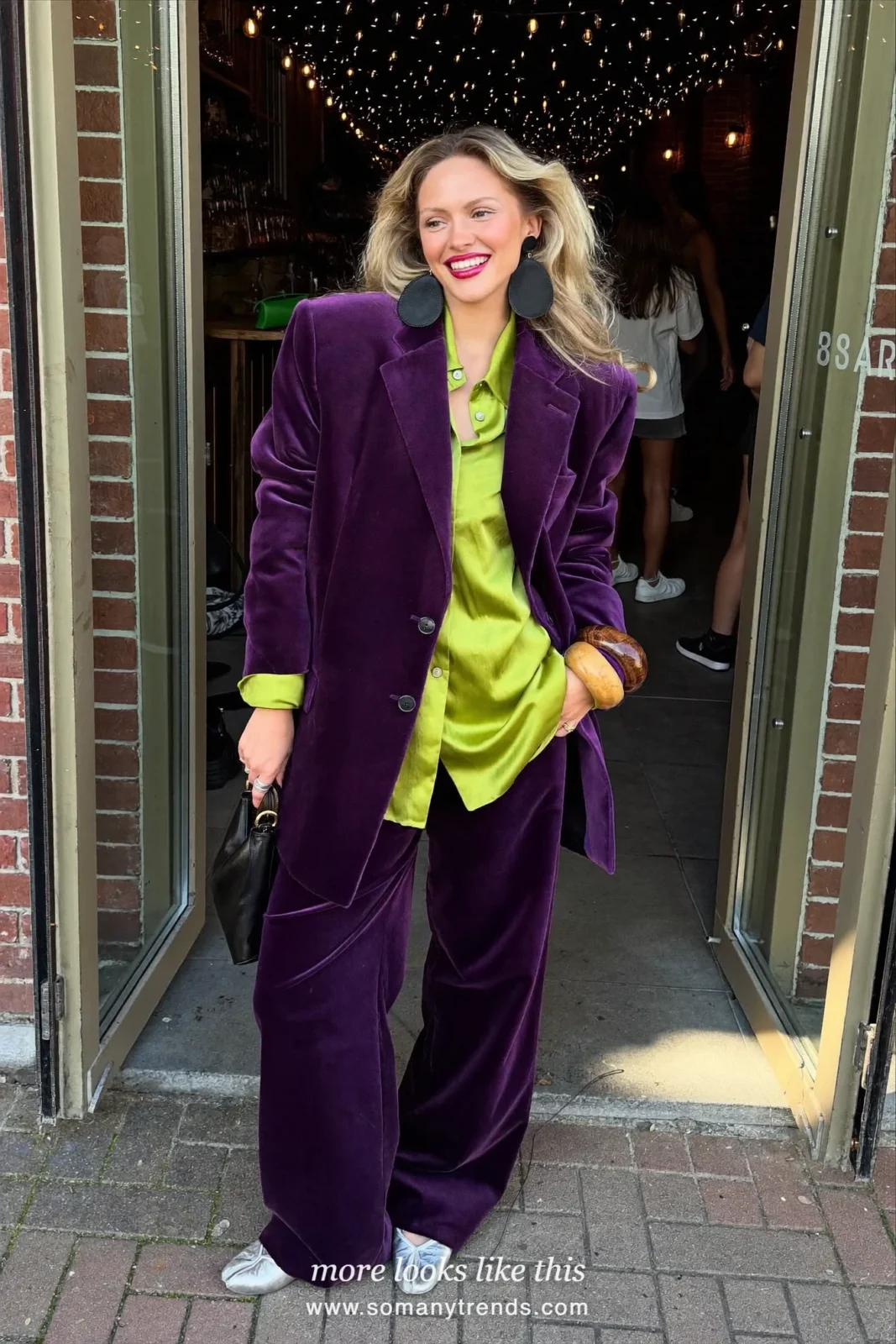 Woman in a deep plum purple velvet blazer and matching wide pants, lime green silk shirt and silver ballet flats, outfit 7