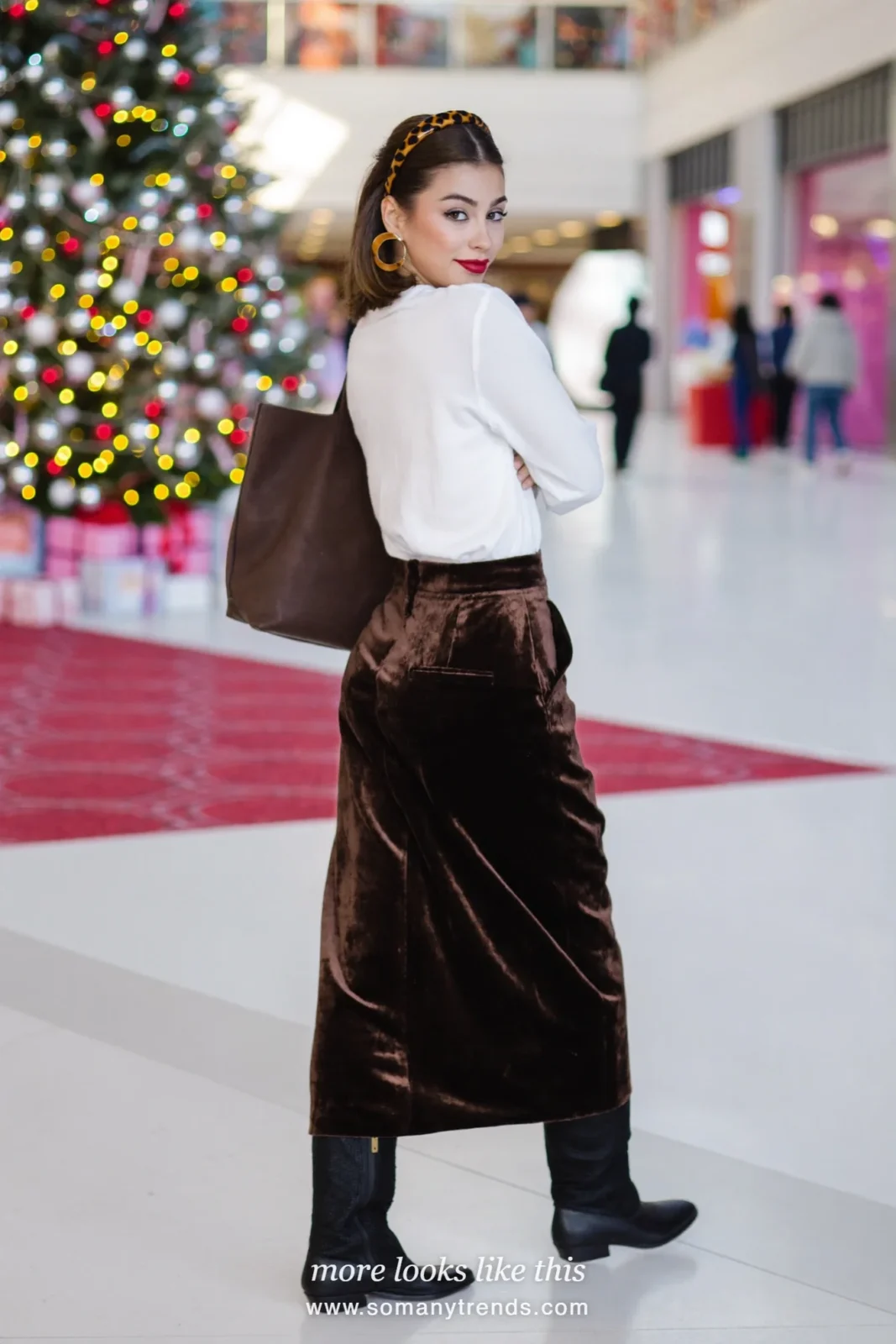 Woman in a dark chocolate brown velvet midi skirt, white tee and tall flat boots, outfit 22