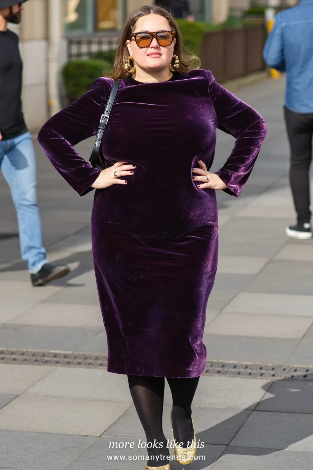 Woman in a deep plum purple velvet midi dress and gold flats, outfit 23