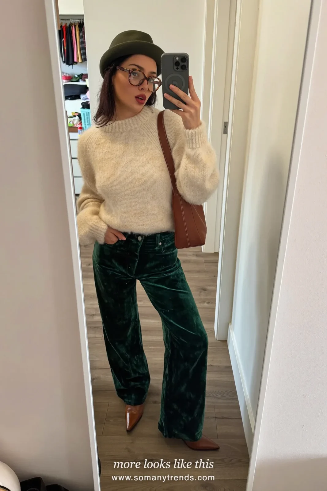 Woman in emerald green velvet wide pants, cream knit sweater, cognac boots and cognac bag, outfit 27