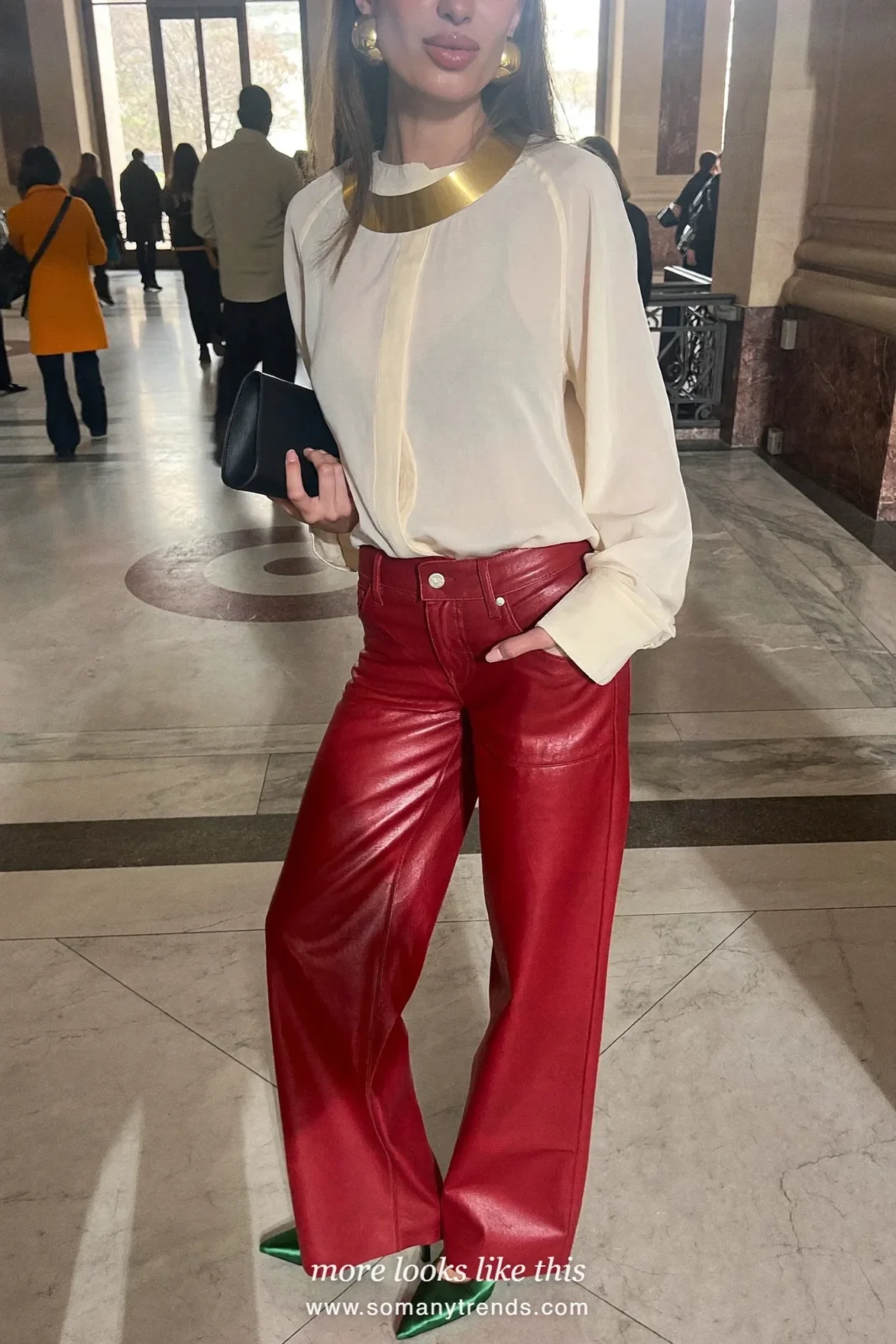 Woman in an ivory silk blouse, red soft matte leather straight pants, emerald green satin pointed pumps and a black clutch, look 10