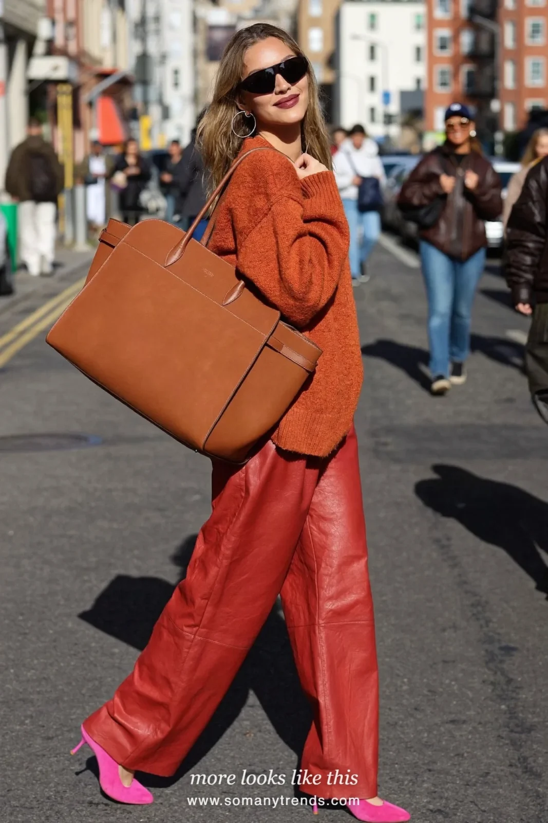 Woman in a burnt orange knit, red soft matte leather straight pants, hot pink suede pumps and a tan tote, look 11