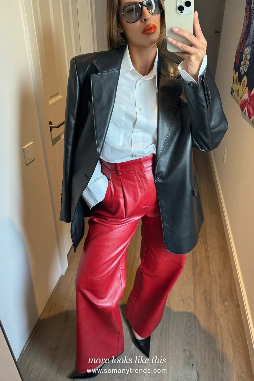 Woman in a white shirt, black blazer, red soft matte leather straight pants and black pointed pumps, look 12