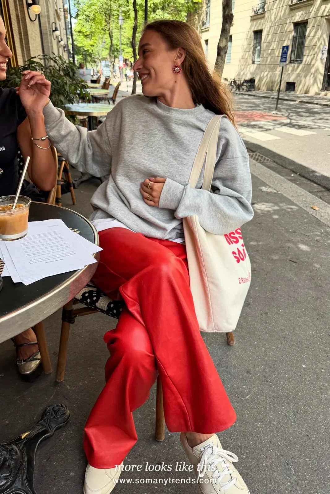 Woman in a gray sweatshirt over a white tee, red soft matte leather straight pants and cream sneakers, look 13