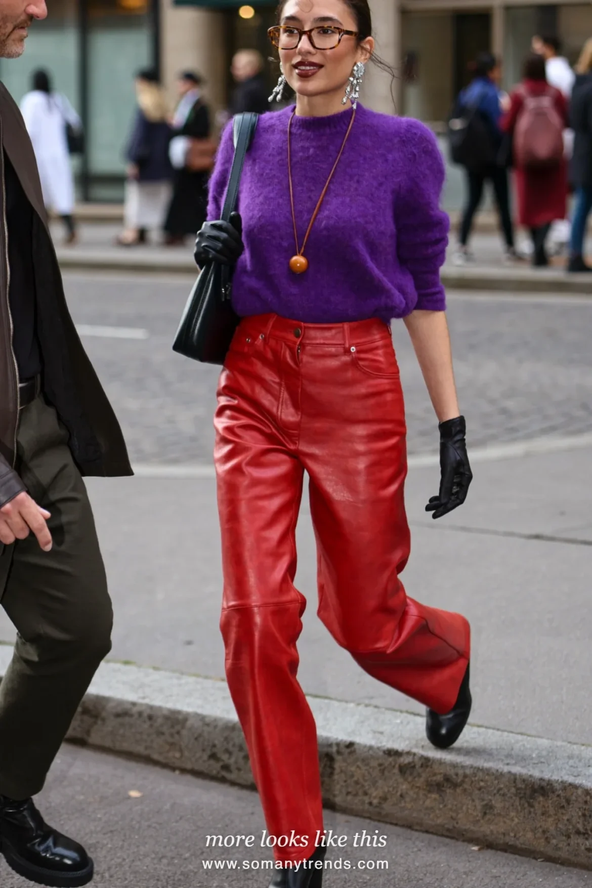 Woman in a violet mohair sweater, red soft matte leather straight pants, black ankle boots and black leather gloves, look 14