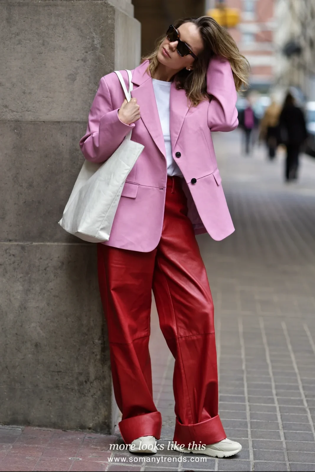 Woman in a pink oversized blazer over a white tee, red soft matte leather straight pants, cream sneakers and a cream tote, look 25