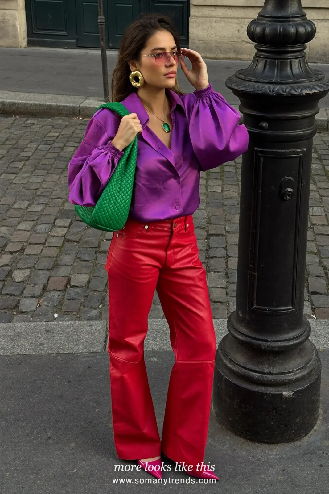 Woman in a violet satin balloon-sleeve blouse, red soft matte leather straight pants, hot pink patent pointed pumps and a green woven bag, look 1