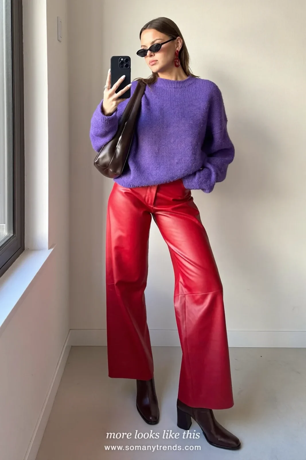 Woman in a violet knit sweater, red soft matte leather straight pants, chocolate brown ankle boots and a brown bag, look 27